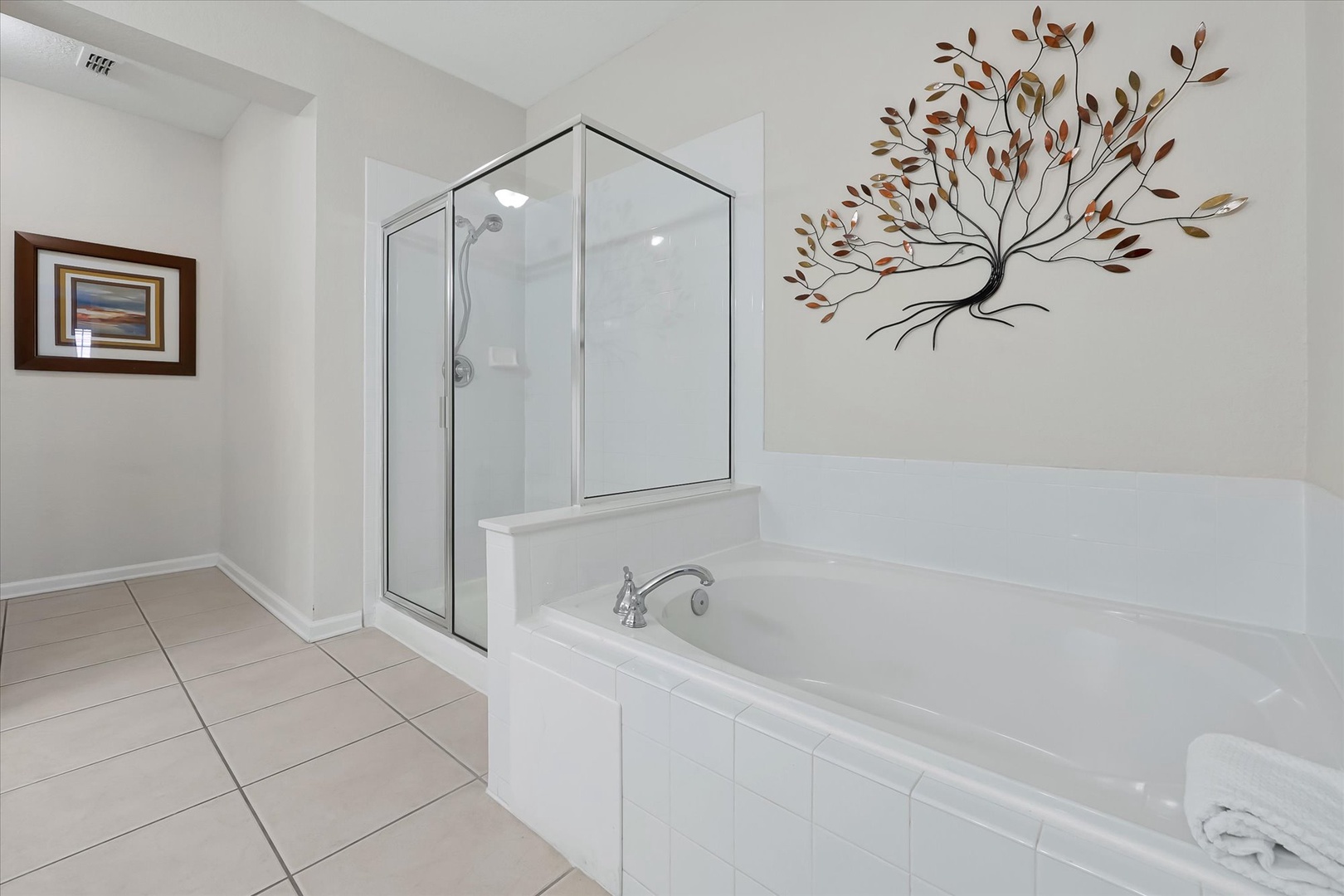 Unwind in your private spa-like bathroom featuring a deep soaking tub and separate glass shower—your perfect retreat after exploring.