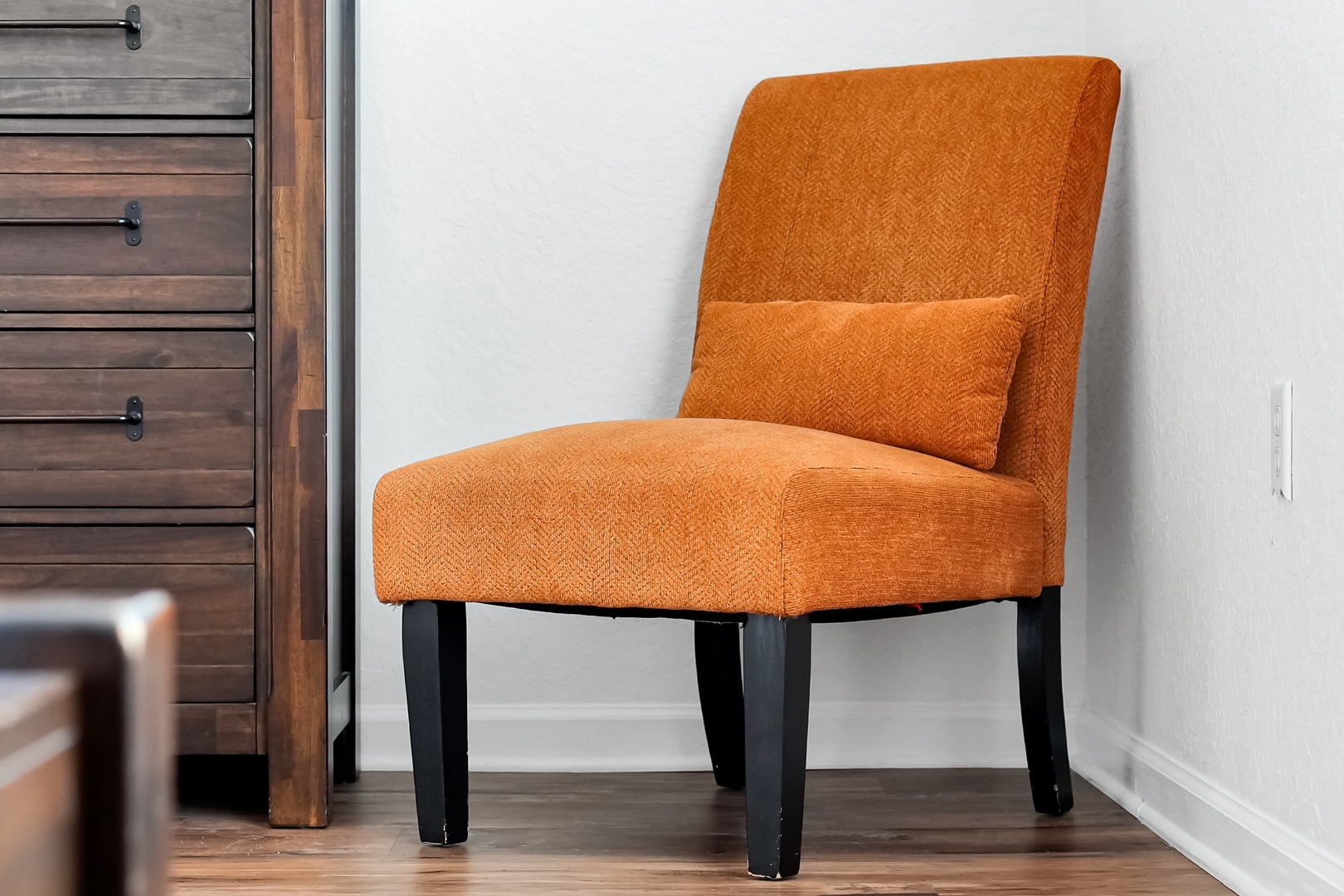 Settle into this inviting orange accent chair, your perfect spot for reading or simply unwinding after a day of exploring.