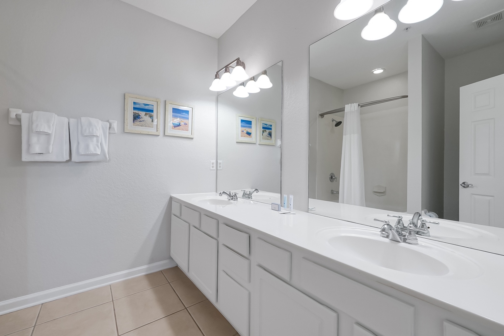 Refresh in your spacious master bathroom with dual vanities, bright lighting, and fresh towels awaiting your arrival.