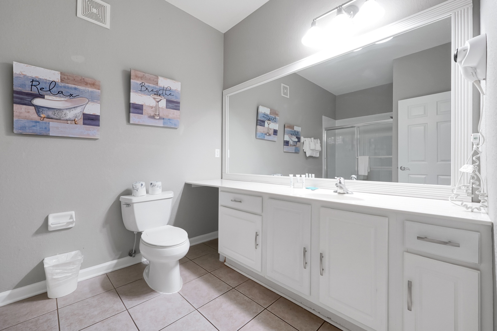 Step into your tranquil bathroom sanctuary, where spa-like fixtures and soft gray tones create a refreshing escape. Fresh towels, a spacious vanity, and soothing decor set the stage for your perfect morning routine.