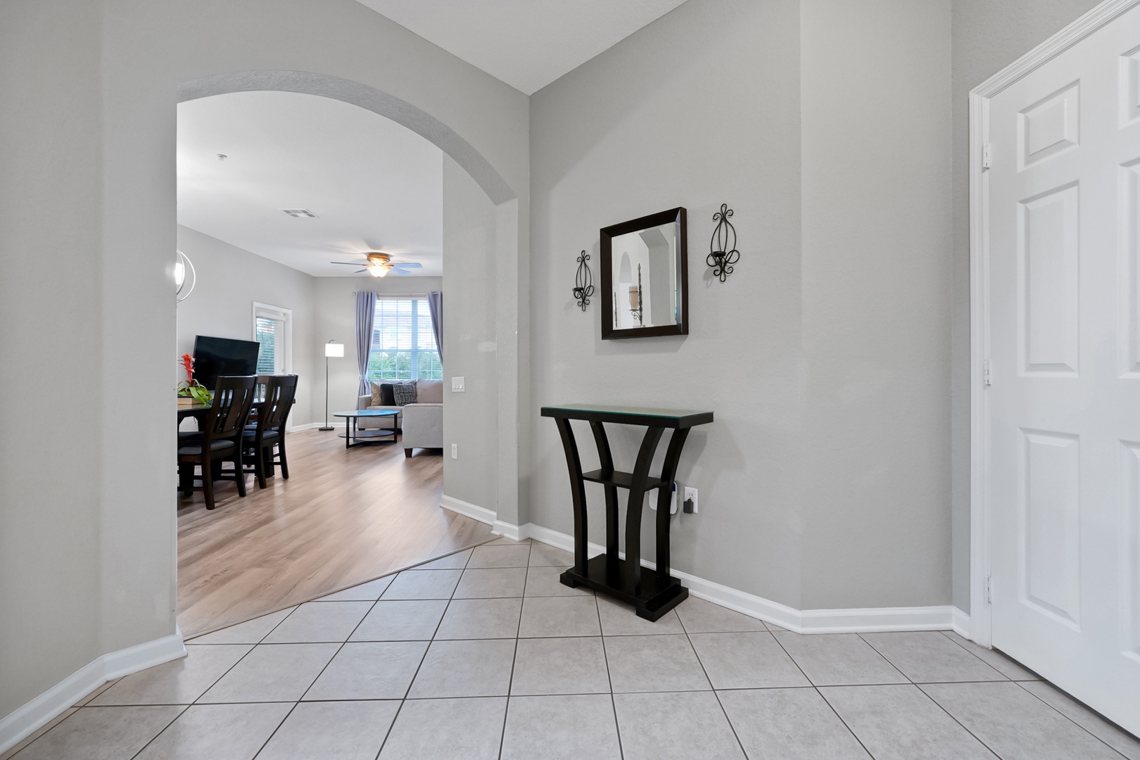 Step into your inviting entryway, where soft neutral tones and warm wood floors flow seamlessly into the open living space, instantly making you feel at home.