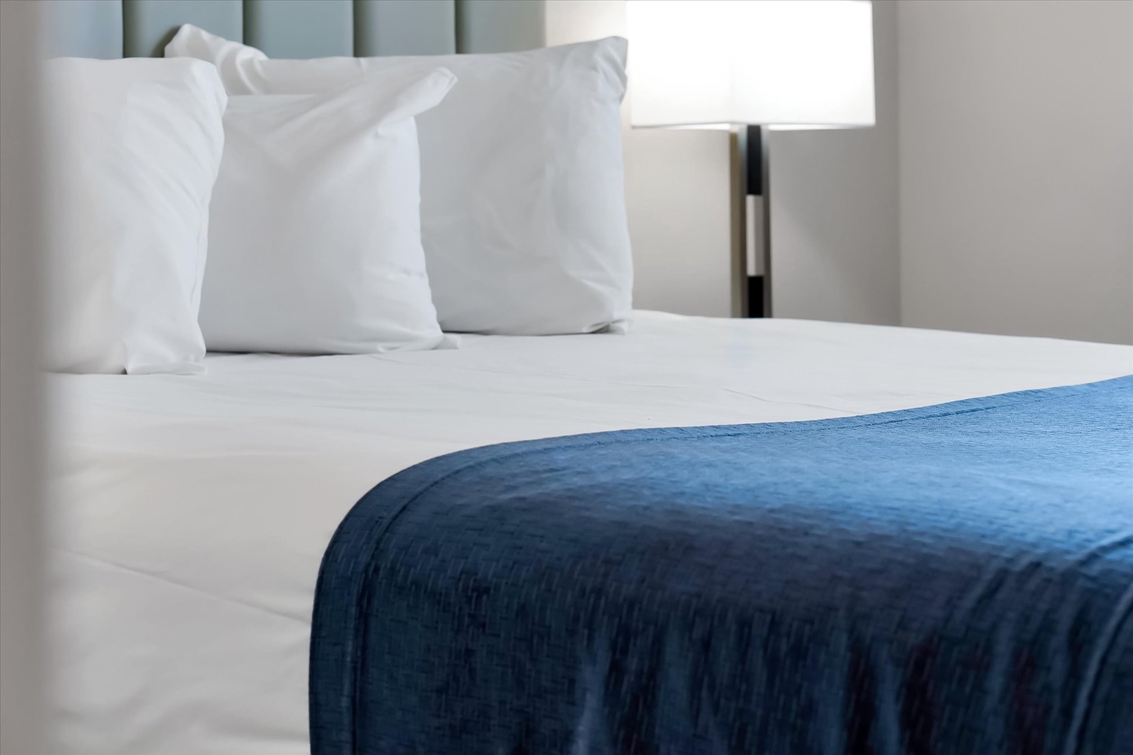 Sink into crisp white linens and a luxurious navy throw for your most restful night's sleep yet.