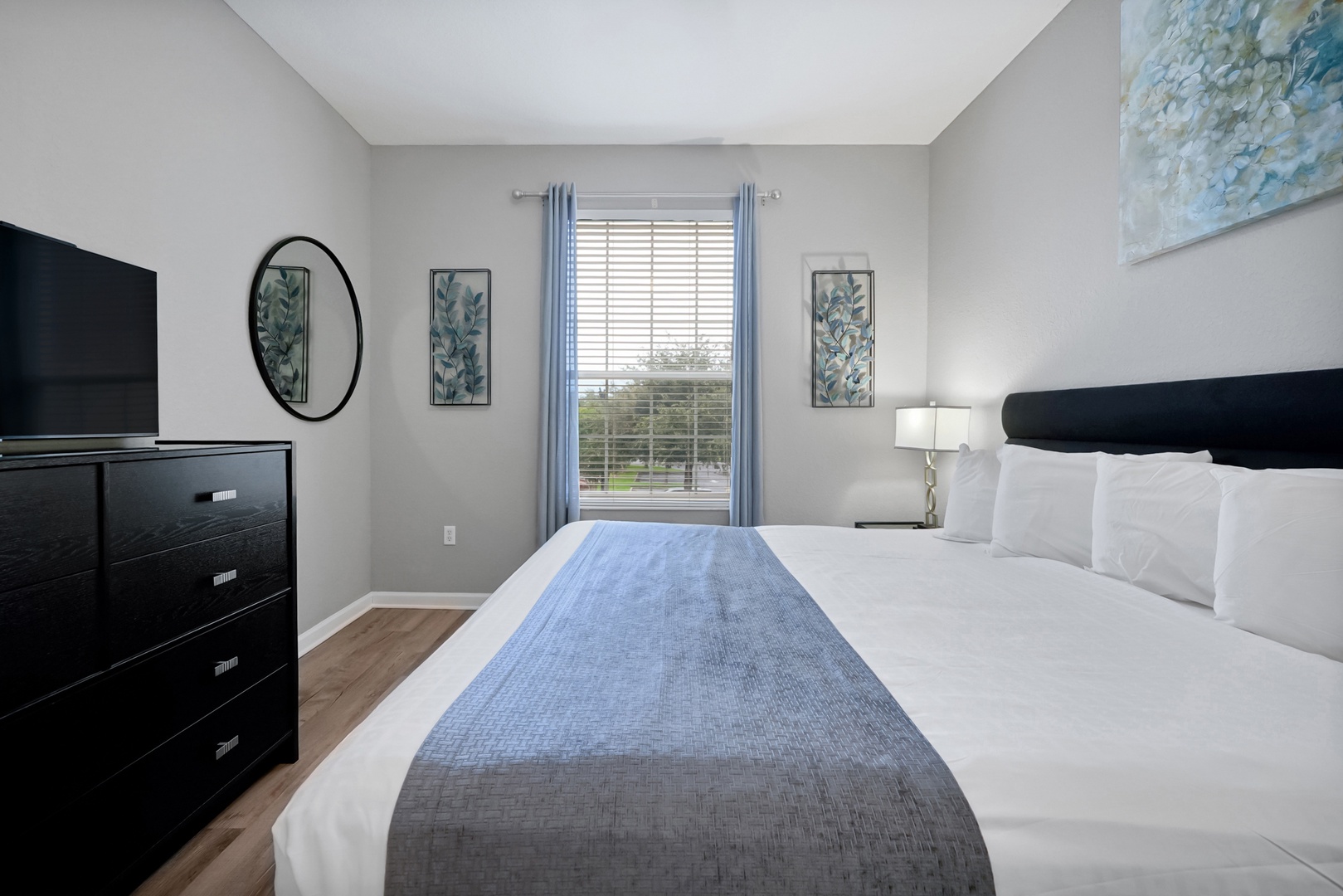 Your peaceful retreat awaits with crisp linens, calming coastal touches, and soft natural light filtering through the window. Unwind in this serene bedroom designed for restful nights and relaxed mornings.