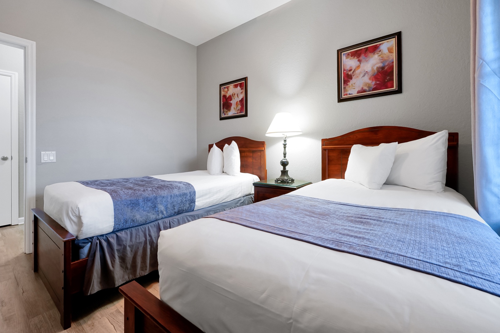 Your bedroom features two plush beds with crisp white linens and soft blue accents, creating a serene space where rest comes easy.