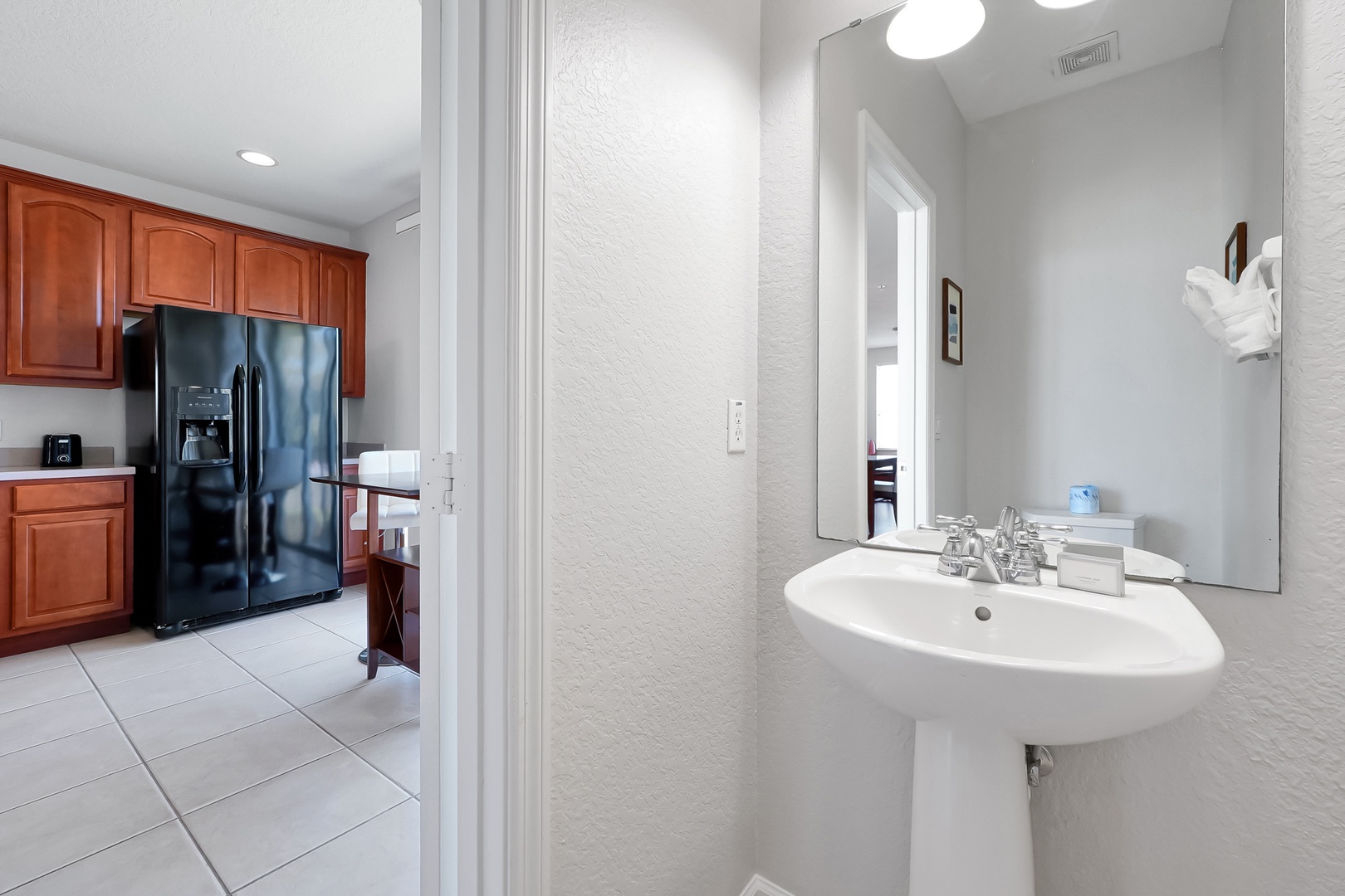 Step into your bright, convenient space where a powder room sits just steps from the fully-equipped kitchen—perfect for quick freshening up during your stay.