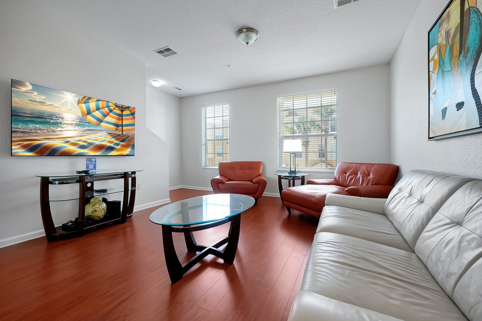 Sink into plush leather seating while enjoying your favorite shows on the large TV in this bright, coastal-themed living space.