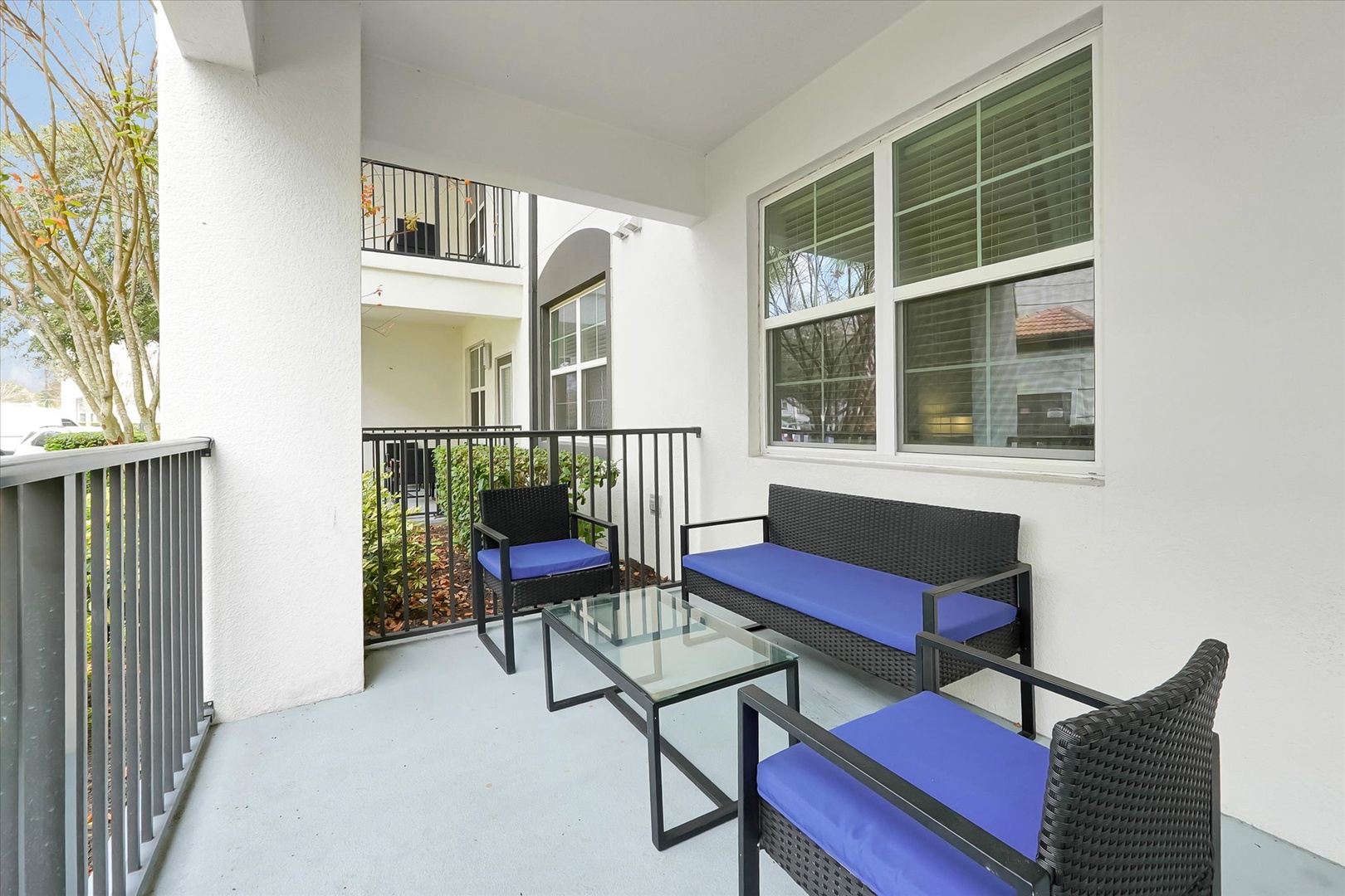 Step onto your private balcony and sink into comfortable seating with vibrant blue cushions—perfect for morning coffee or evening relaxation.