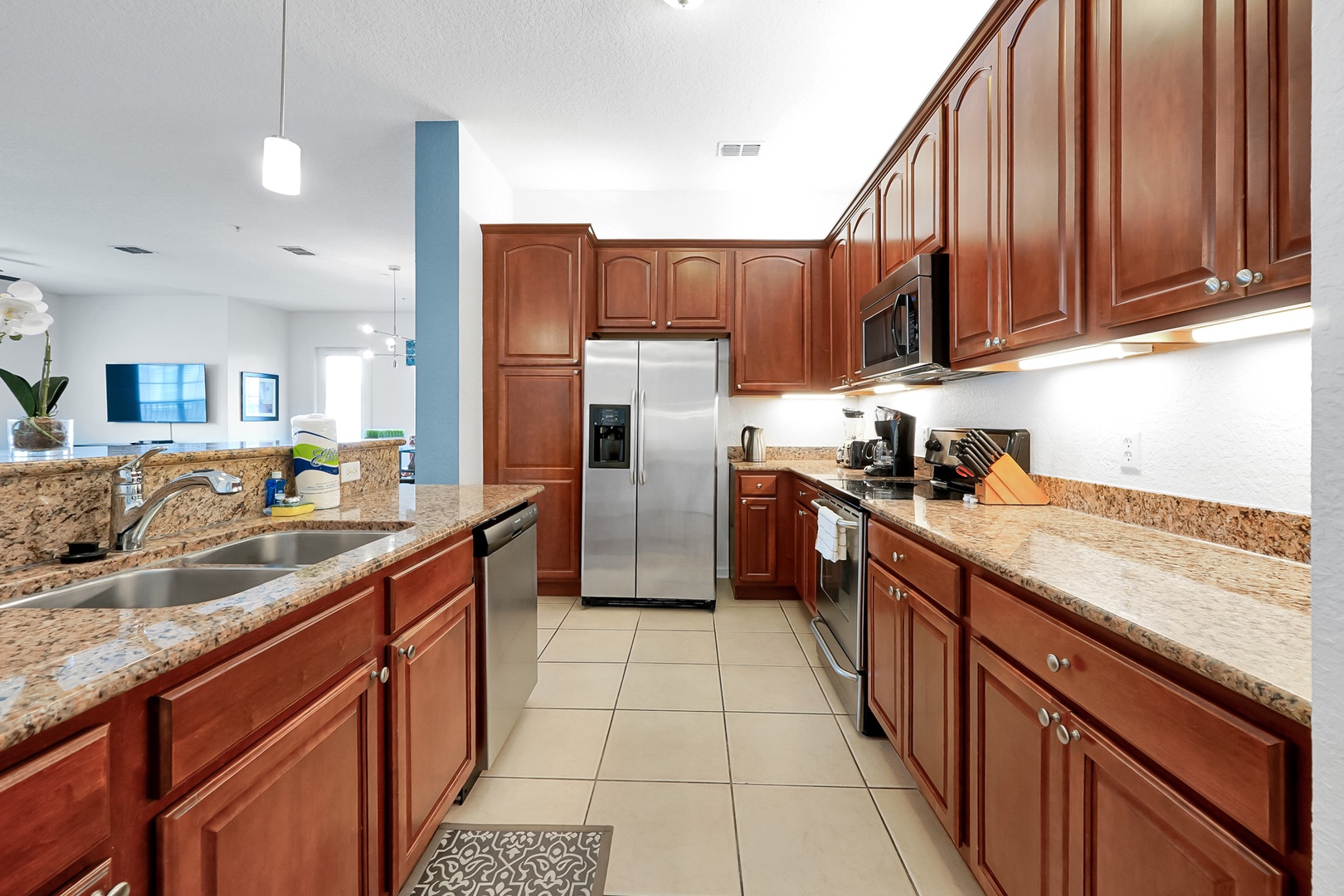 Step into your fully equipped kitchen featuring gleaming granite counters, rich wood cabinetry, and stainless steel appliances—everything you need to prepare your favorite meals in style.