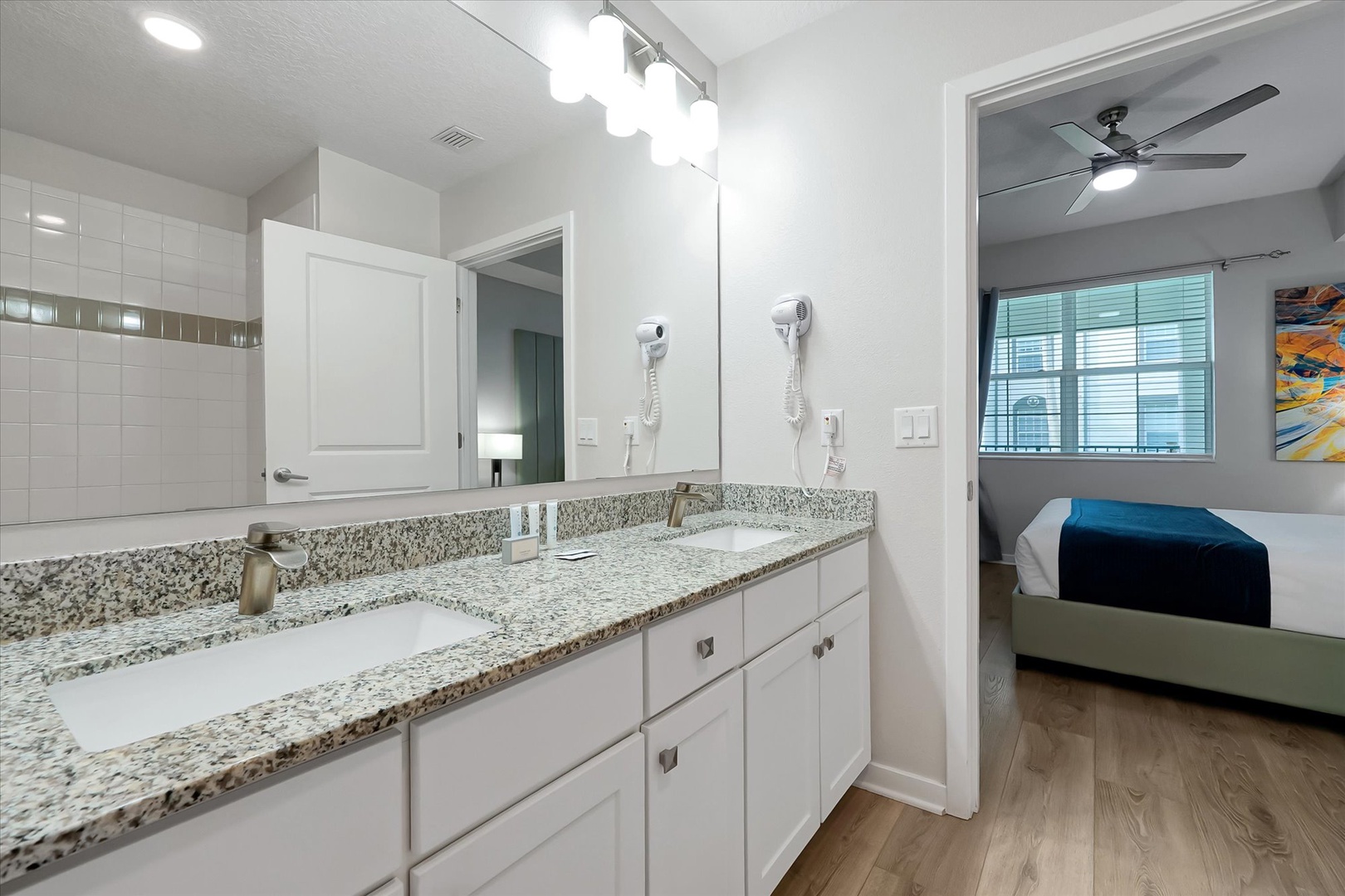 Your private ensuite bathroom features elegant granite countertops, dual sinks, and premium finishes for a luxurious start to your morning routine.