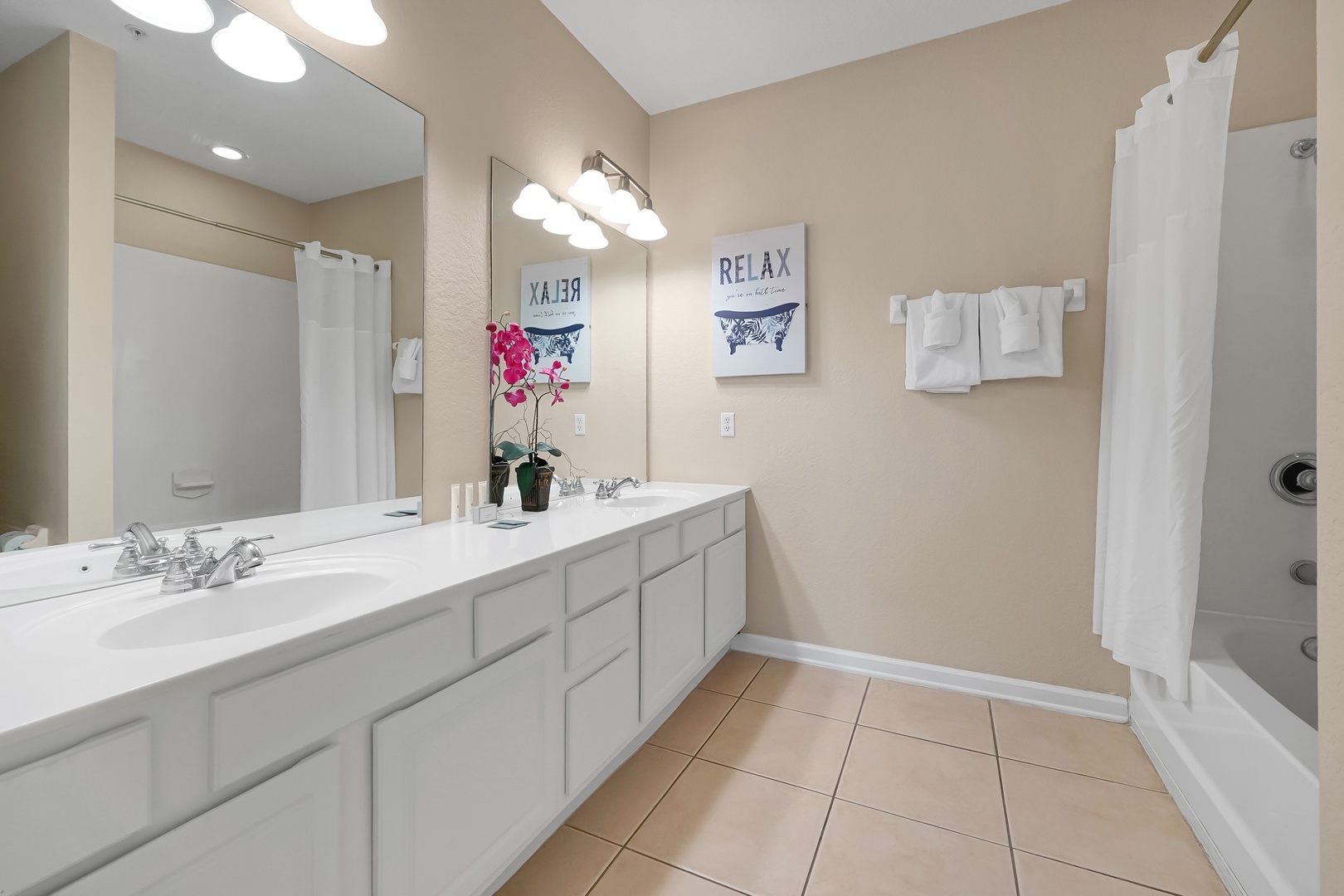 Step into your serene bathroom retreat with dual vanities, fresh towels, and a relaxing tub where you can unwind after exploring.