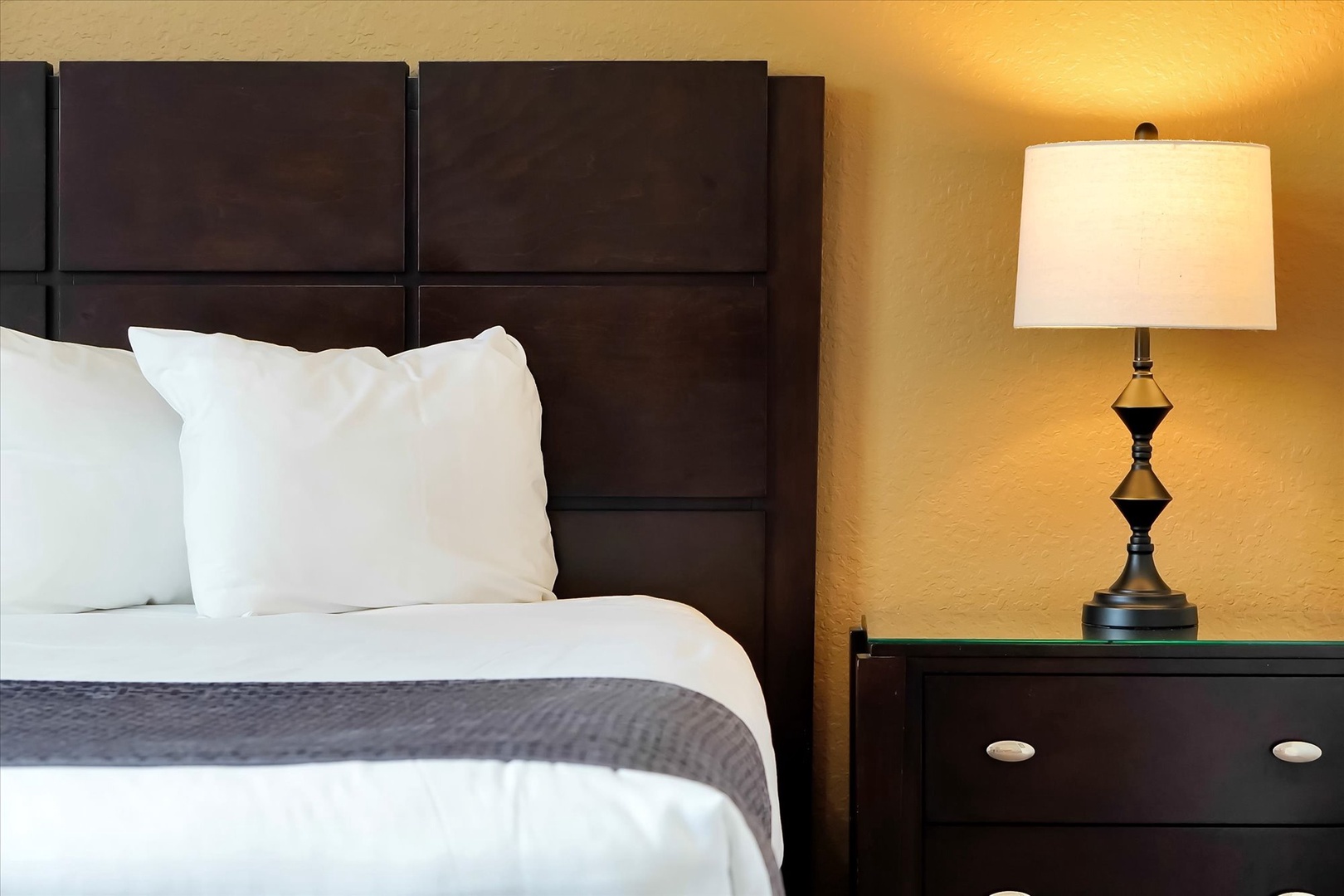 Sink into crisp white linens and let the warm bedside lighting create your perfect evening ambiance.