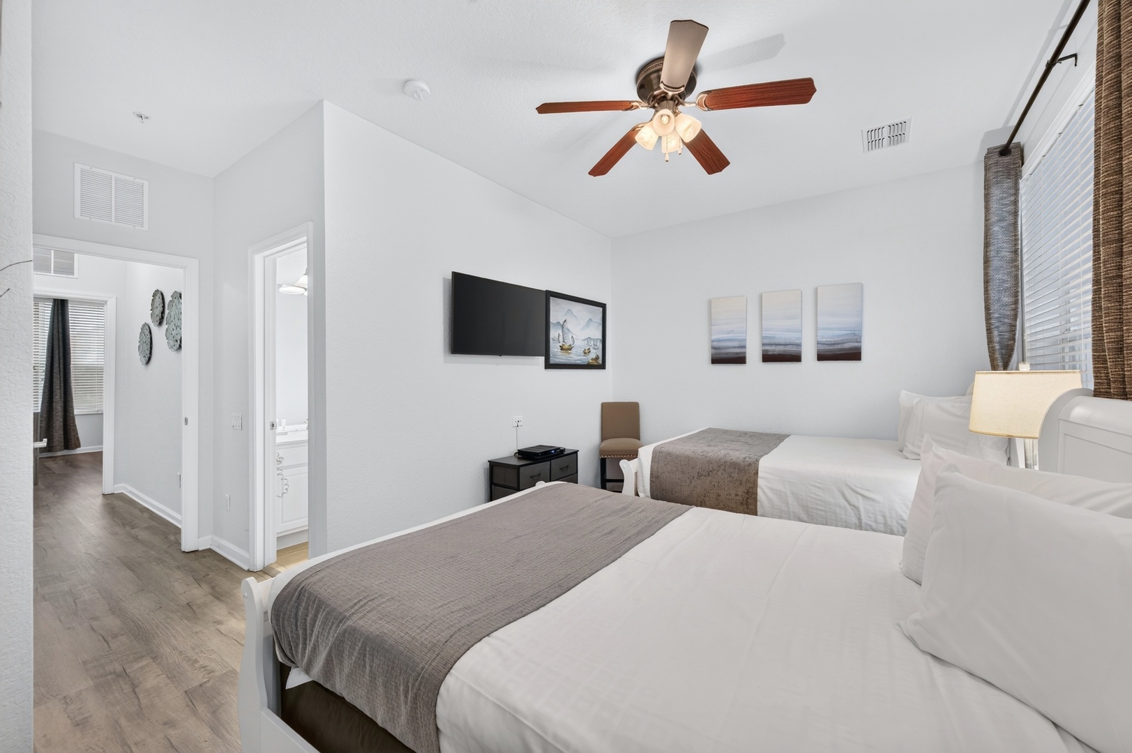 Sink into crisp white linens and relax under the gentle breeze of your ceiling fan. Two cozy beds await, ready for your well-deserved rest.