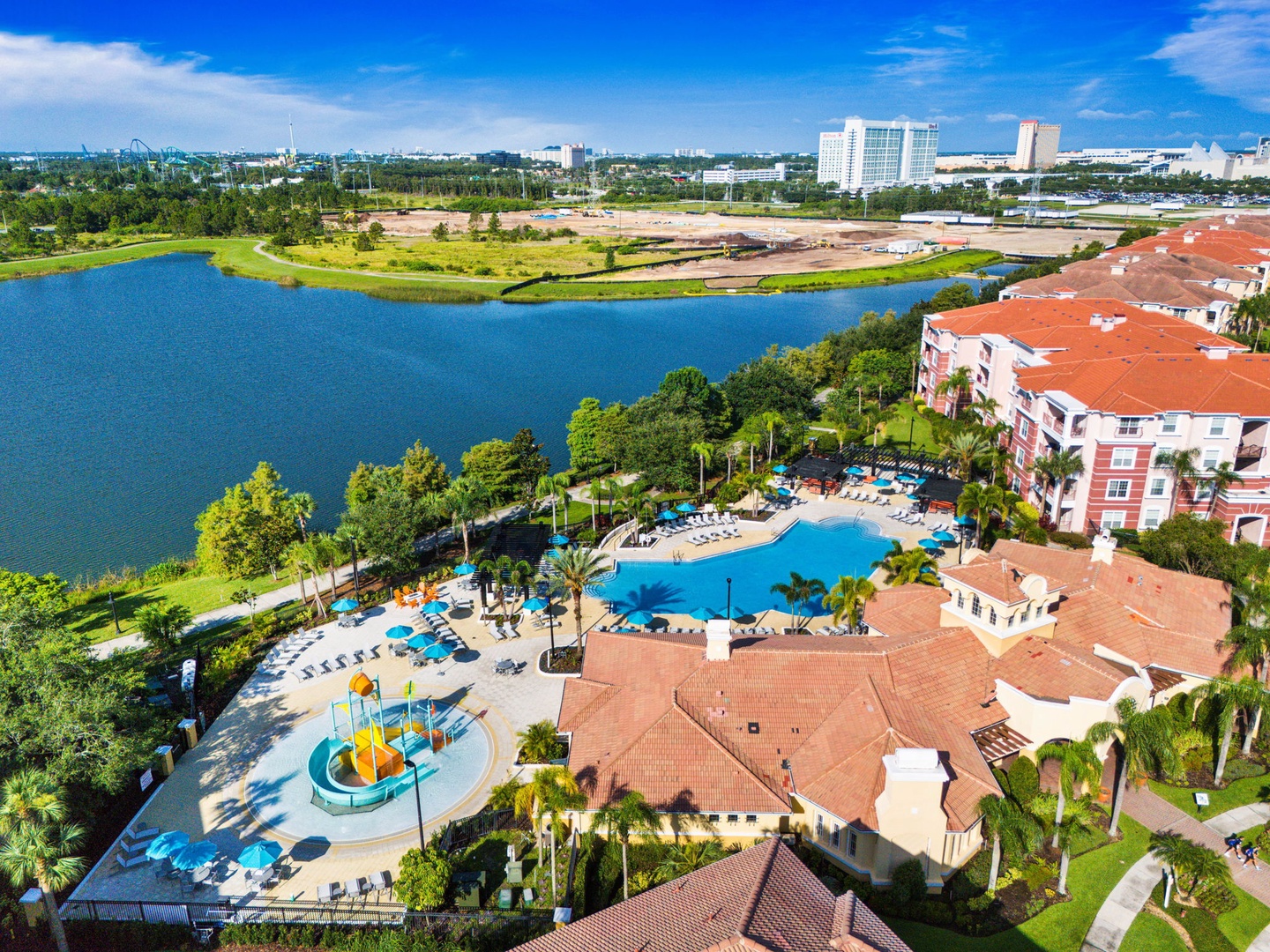 Aerial view of resort property featuring swimming pool, children's play area, and lakefront location with scenic surroundings.