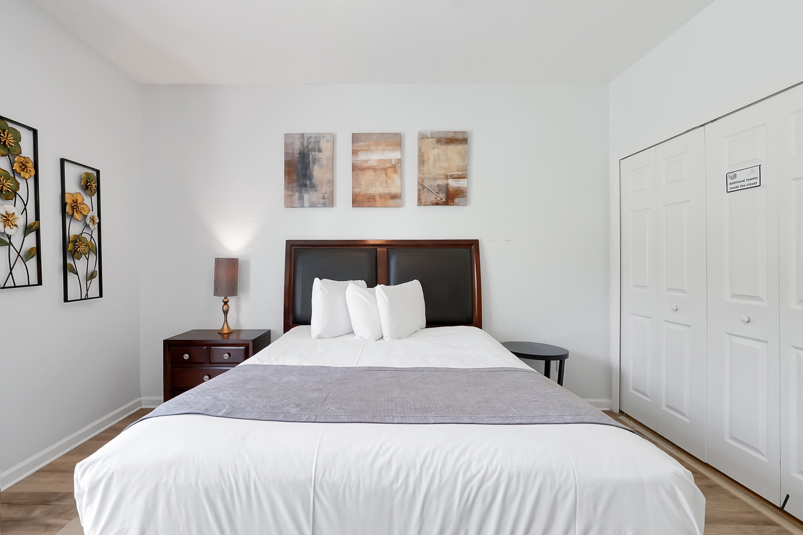 Drift off in your serene bedroom featuring crisp white linens and tasteful artwork that creates a peaceful retreat.