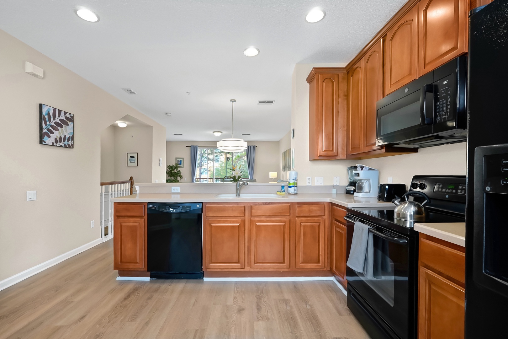 Your spacious kitchen features warm wood cabinets, modern black appliances, and everything you need to prepare meals during your stay.