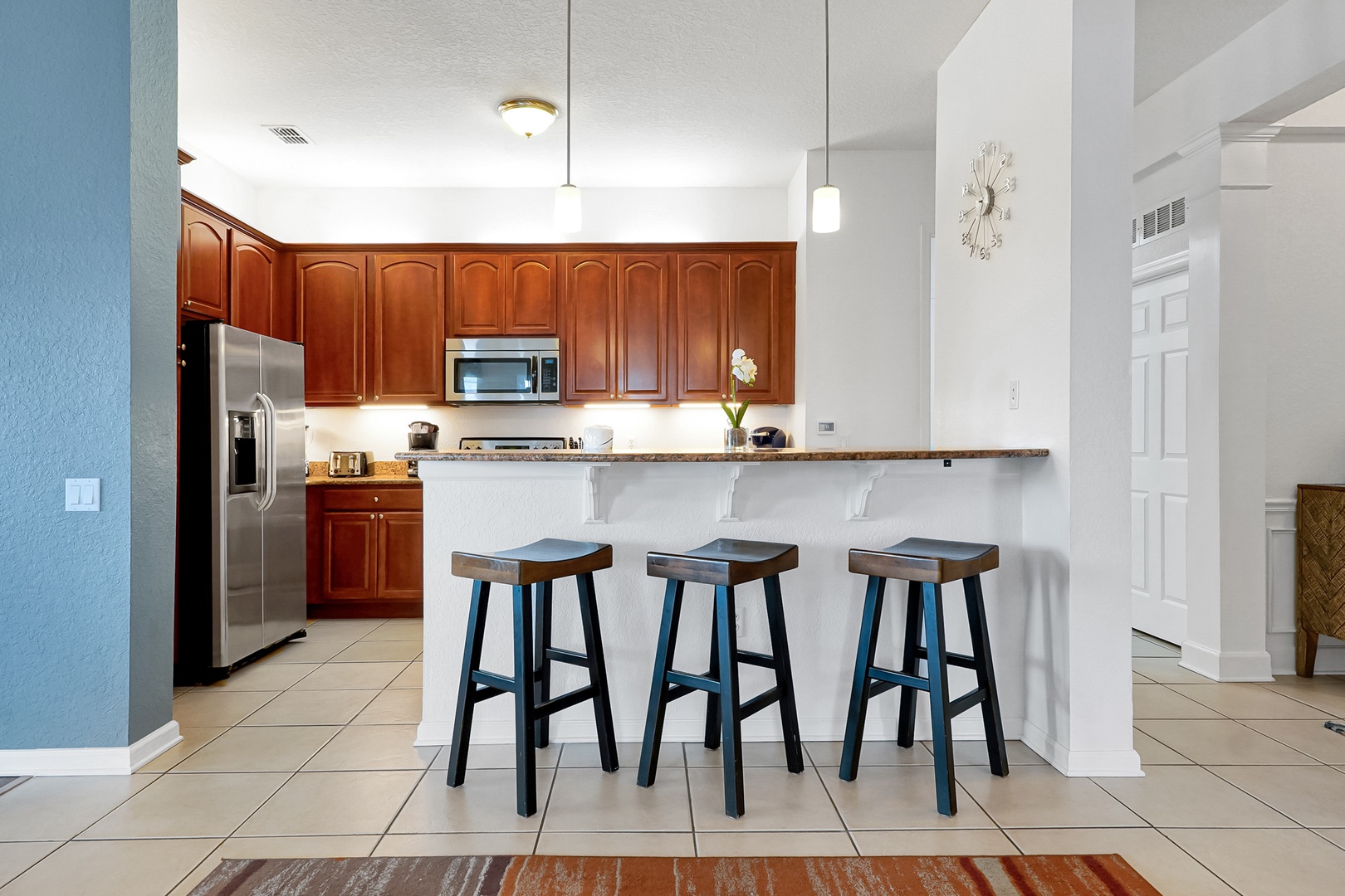 Gather around the breakfast bar for morning coffee or casual meals in your fully equipped kitchen. Rich wood cabinetry, modern appliances, and a bright open layout make cooking feel effortless and inviting.