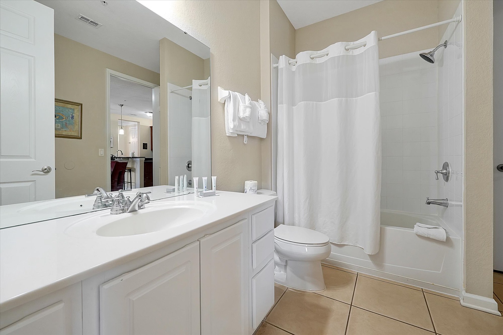 Your pristine bathroom features a spacious tub-shower combo, crisp white linens, and thoughtful amenities for your comfort.