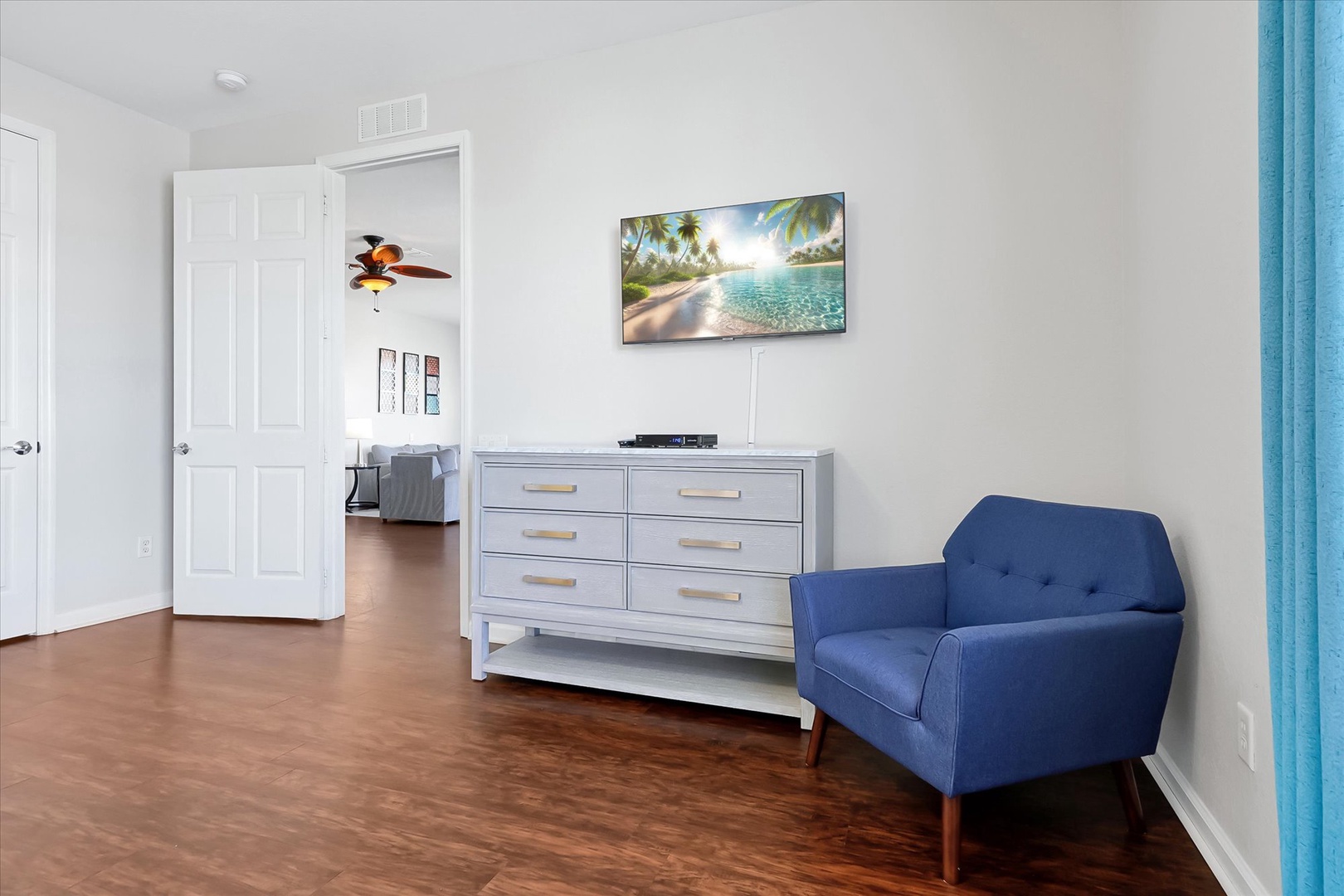 Relax in your cozy blue chair while watching your favorite shows on the wall-mounted TV, with stylish storage nearby.