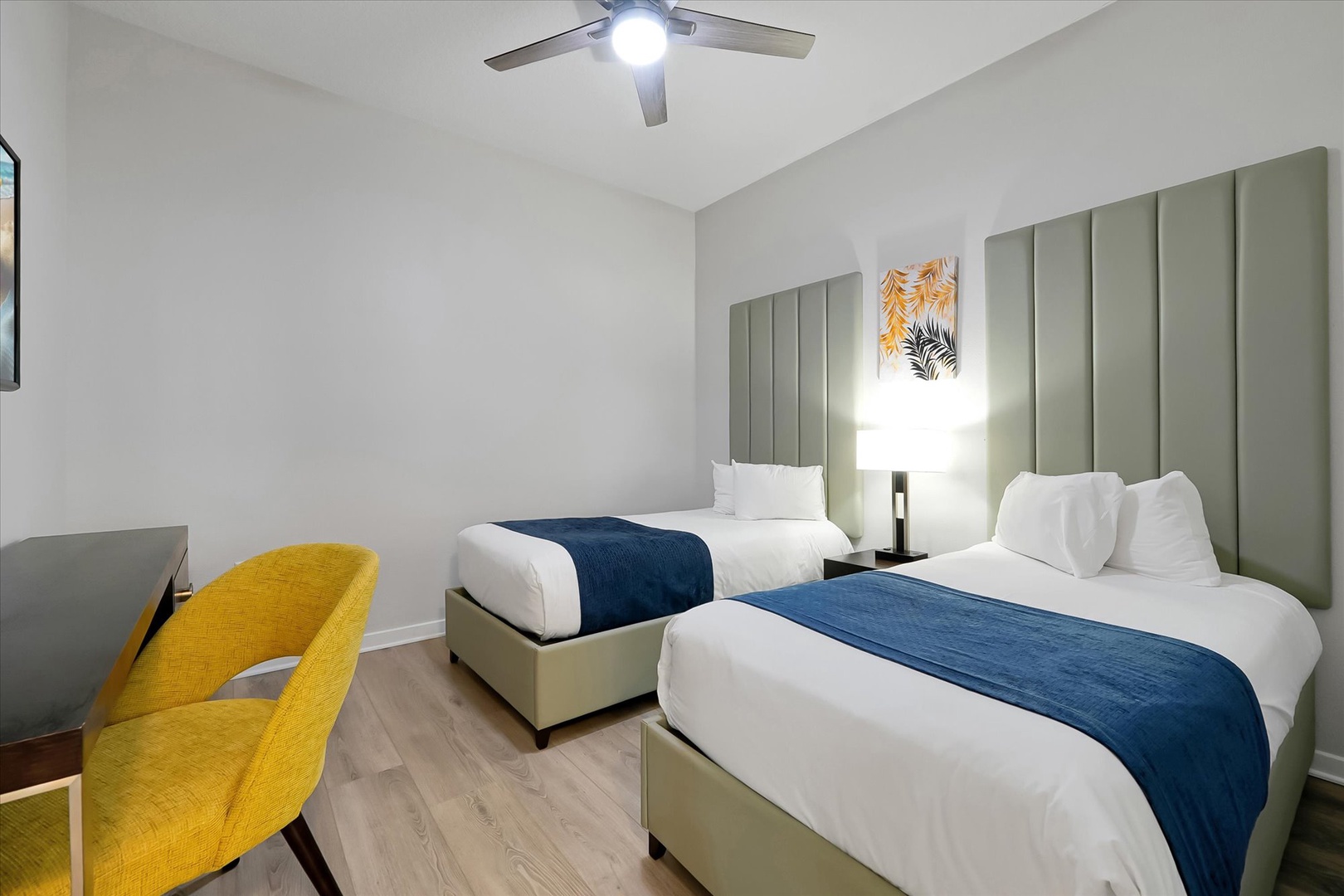 Relax in your stylish twin bedroom with crisp linens, modern headboard, and bright yellow accent chair.