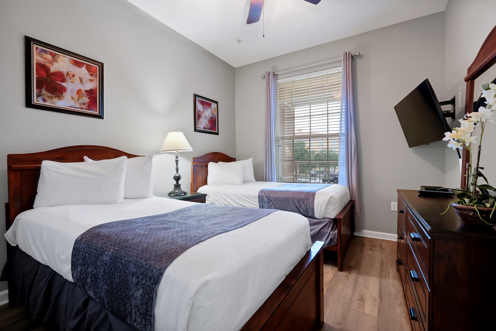 Relax into your comfortable bedroom with two plush beds, crisp linens, and soft natural light streaming through the window—your perfect retreat awaits.