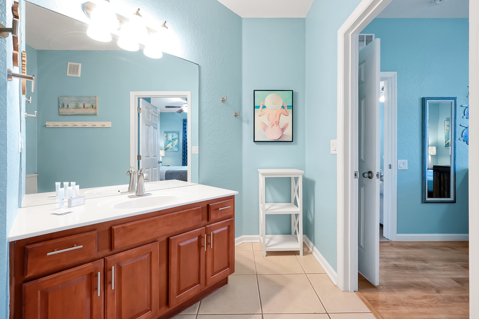 Step into your bright bathroom with calming blue walls, rich wood vanity, and modern fixtures for a refreshing start to each day.