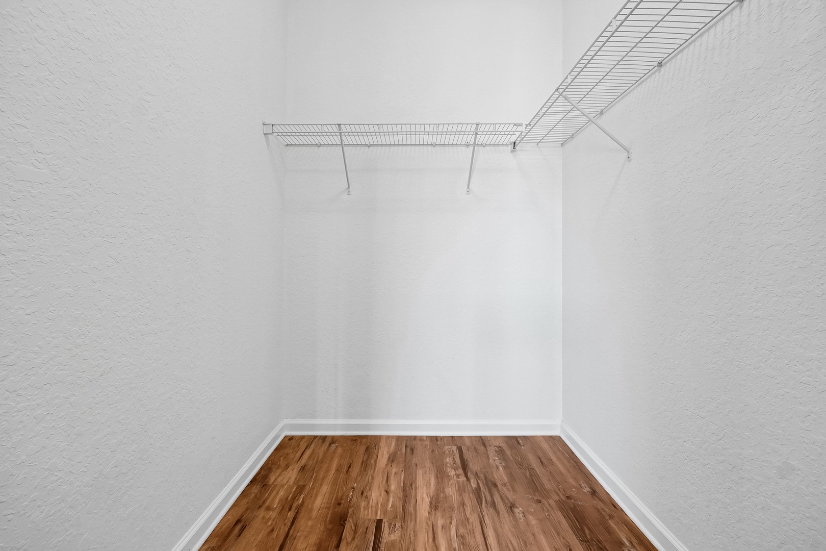 Your spacious walk-in closet features ample shelving and hanging space, giving you plenty of room to organize and settle in comfortably.