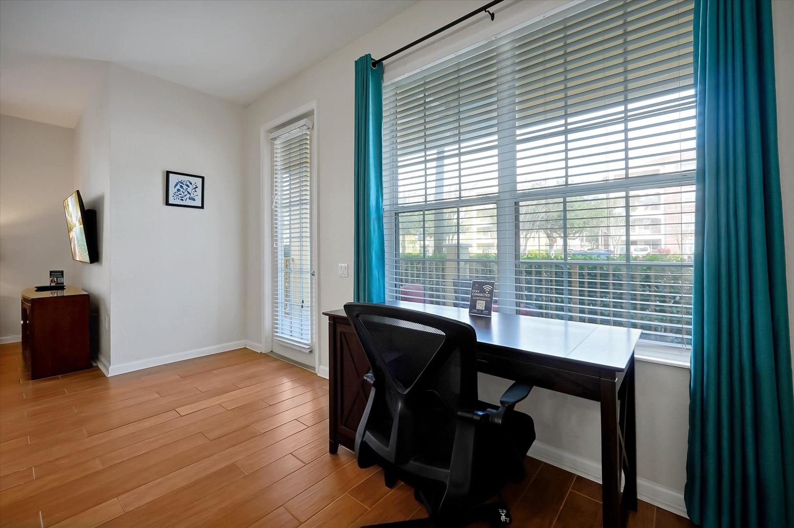 Set up your home office in this bright workspace with large windows and modern desk.