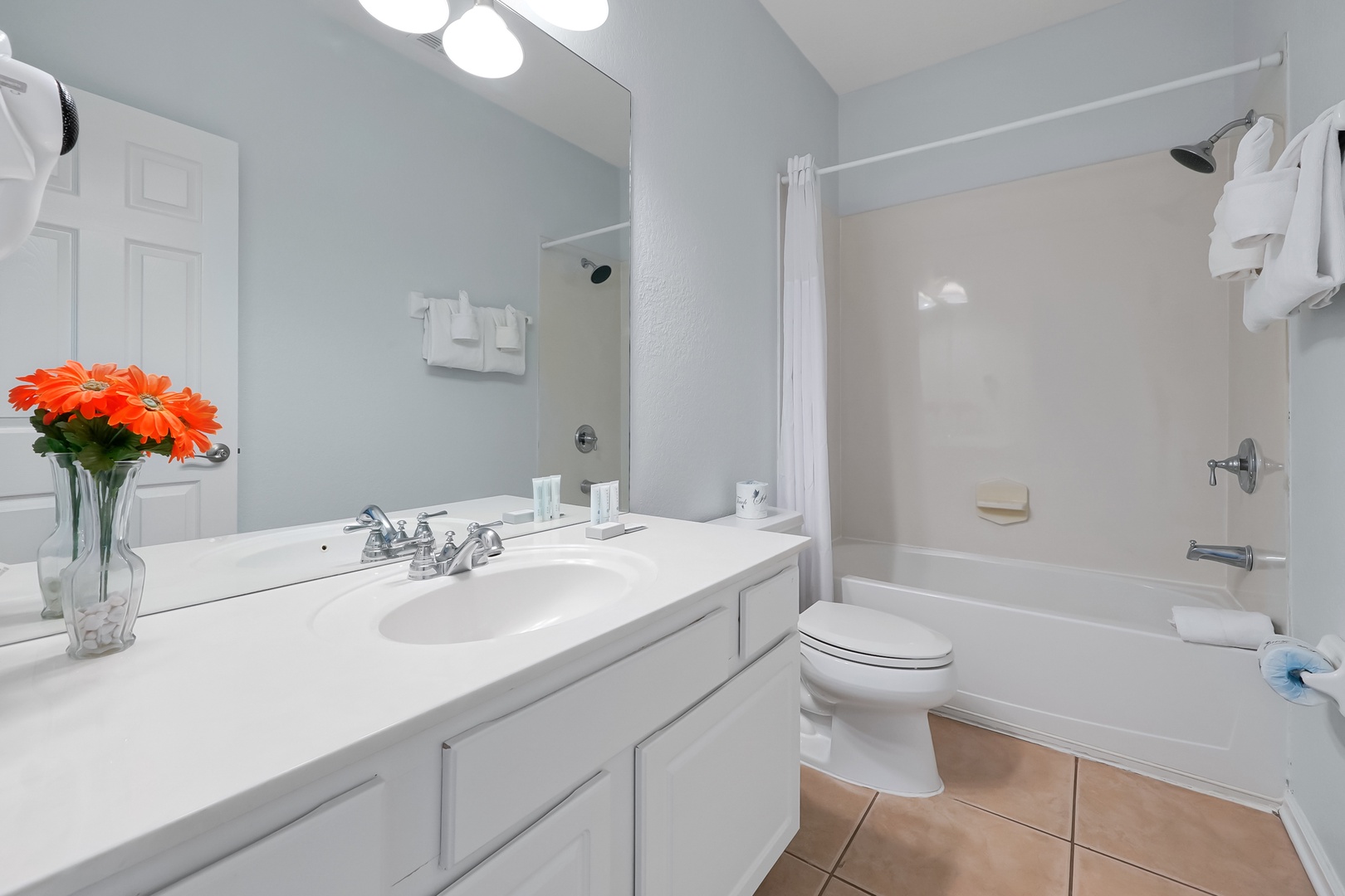 Refresh in your private bathroom featuring a full tub-shower combo, spacious vanity, and thoughtful touches like fresh flowers to make you feel at home.