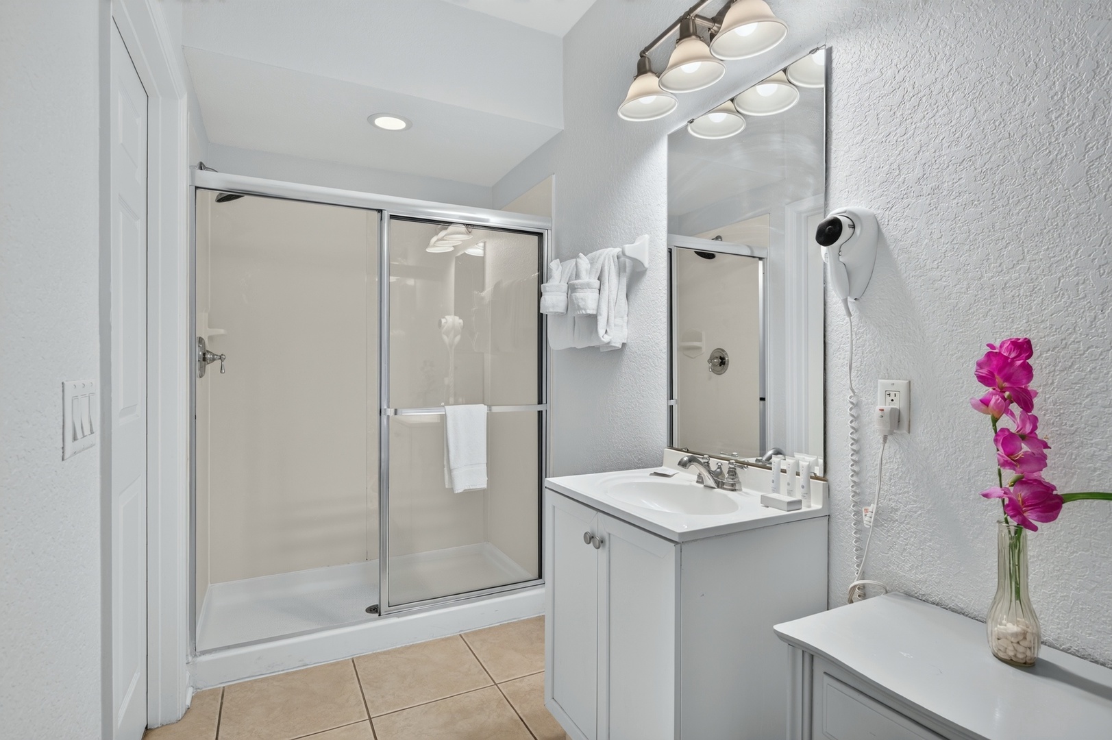 Step into your sparkling clean bathroom, where crisp white towels and modern fixtures await. The bright vanity and spacious shower offer all the comfort you need to refresh after a day of adventure.