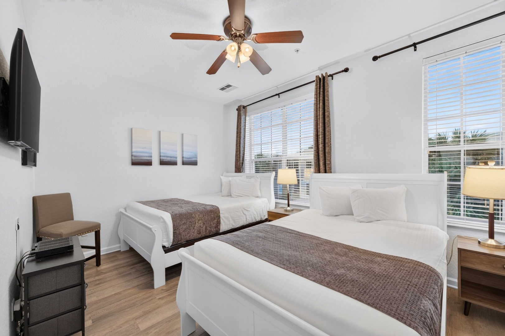 Bright, comfortable bedroom with two plush beds and generous natural light—your peaceful retreat after exploring. The ceiling fan keeps you cool on warm days, and the TV provides entertainment for quiet evenings.