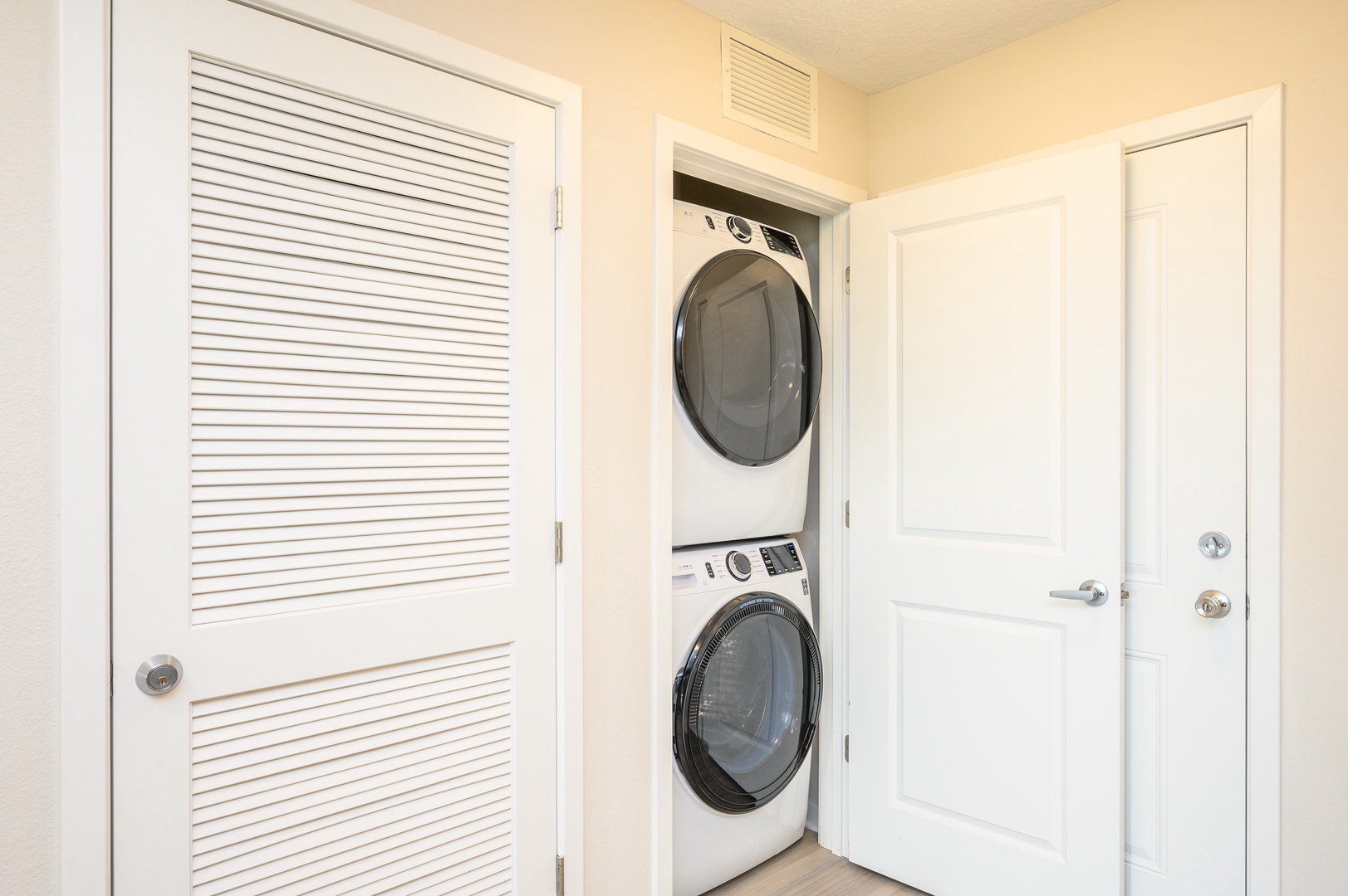 Your in-unit washer and dryer tucked neatly behind white doors make fresh linens and clean clothes effortless during your stay.