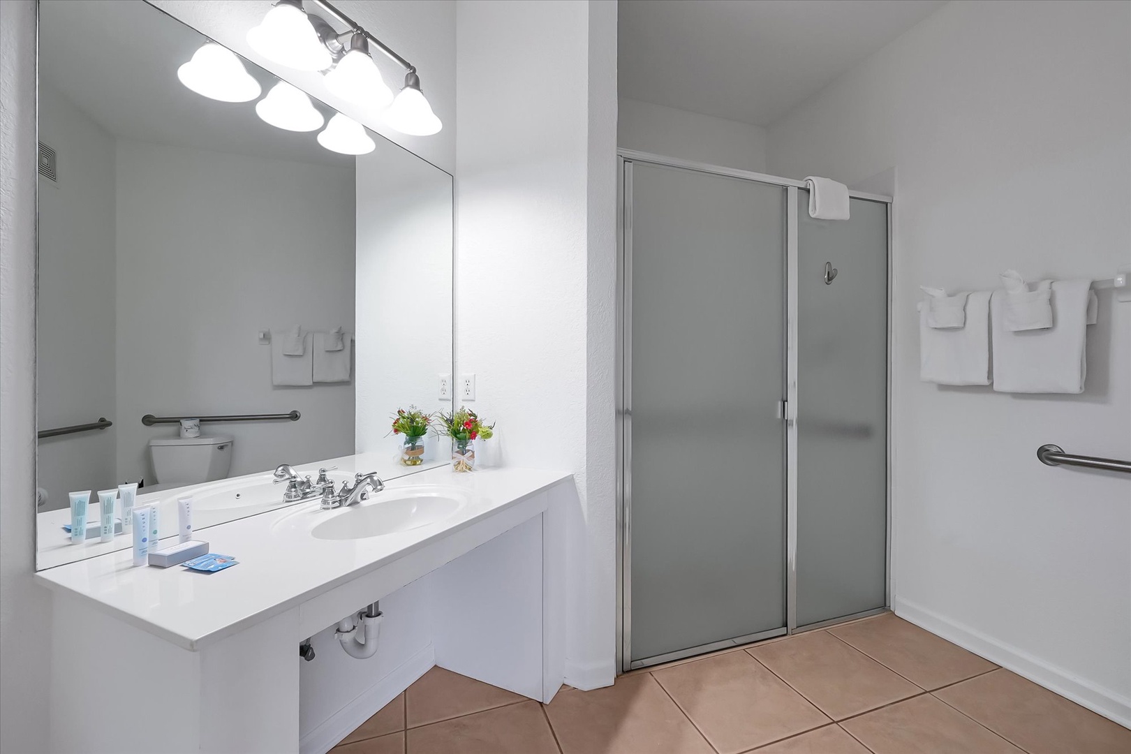 Step into your private spa-like bathroom featuring a spacious vanity, ADA shower, and thoughtful accessibility features for ultimate comfort.