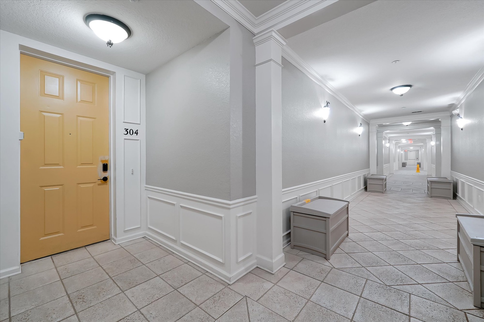 Welcome to your elegant hallway with sophisticated tile floors and classic architectural details leading to your comfortable room.