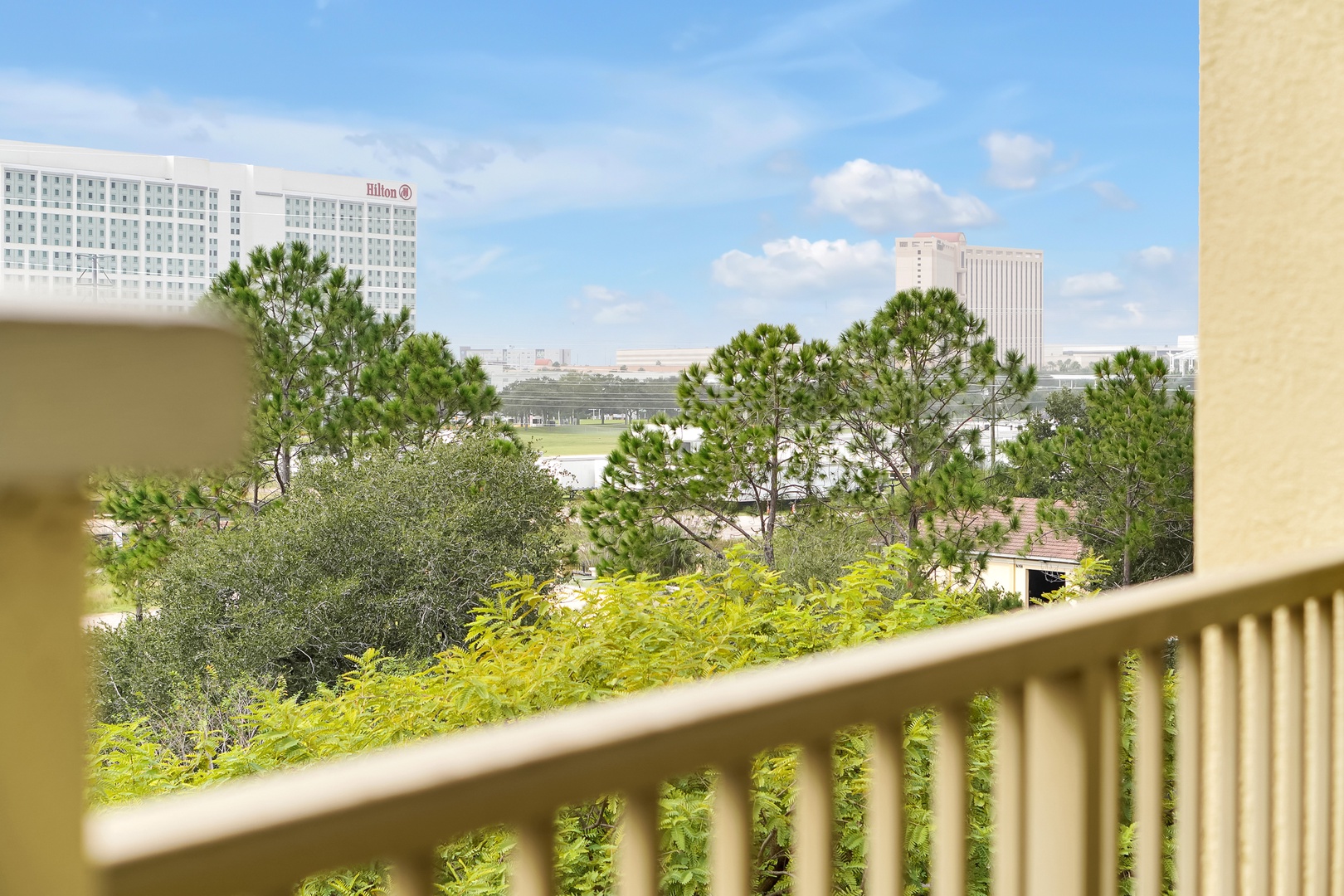 Take in the cityscape from your private balcony, where lush greenery frames views of nearby hotels and landmarks—a peaceful perch above the vibrant surroundings.