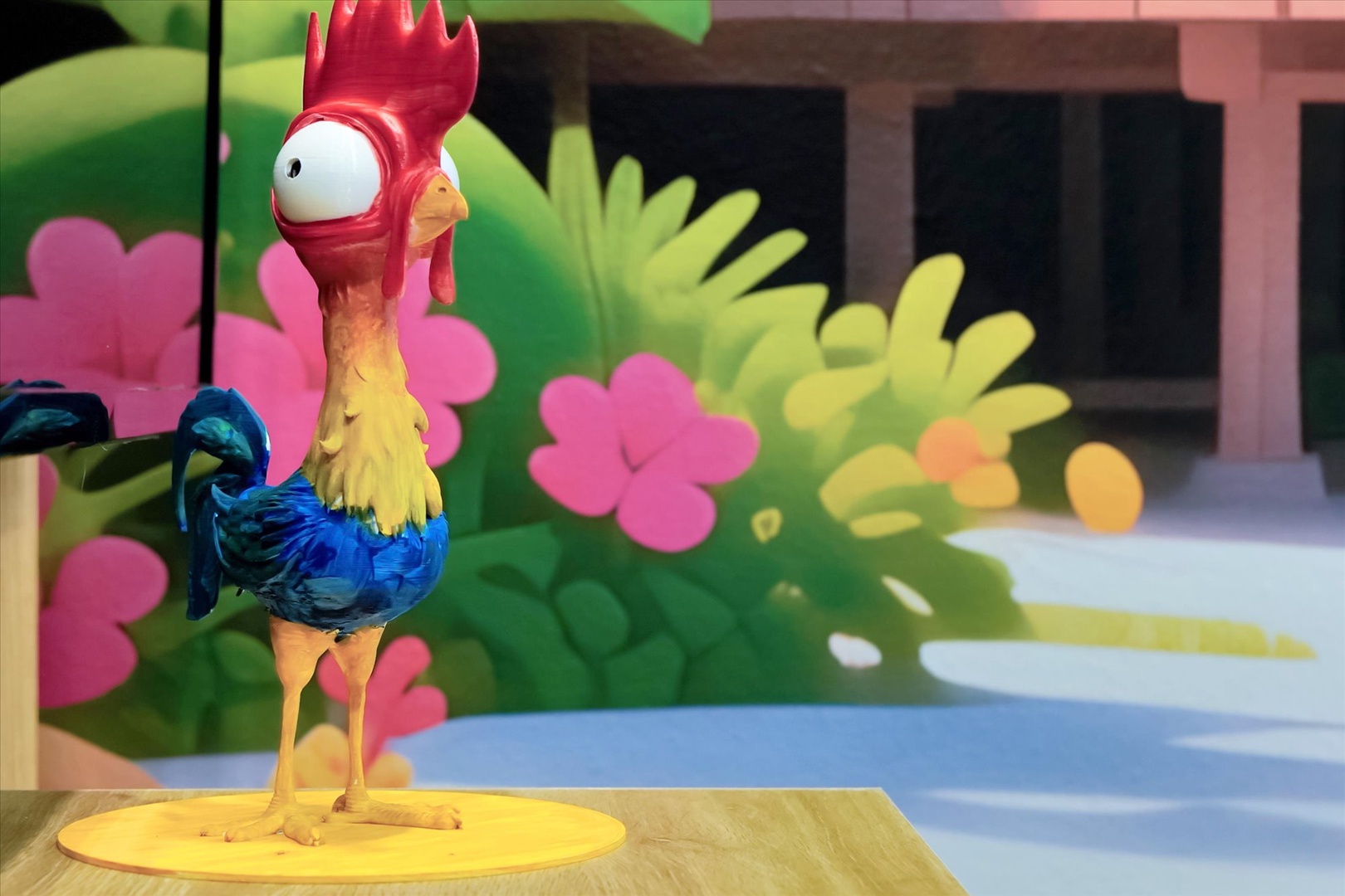 A colorful rooster figurine greets you near vibrant tropical flowers, adding playful character to your island-inspired escape.