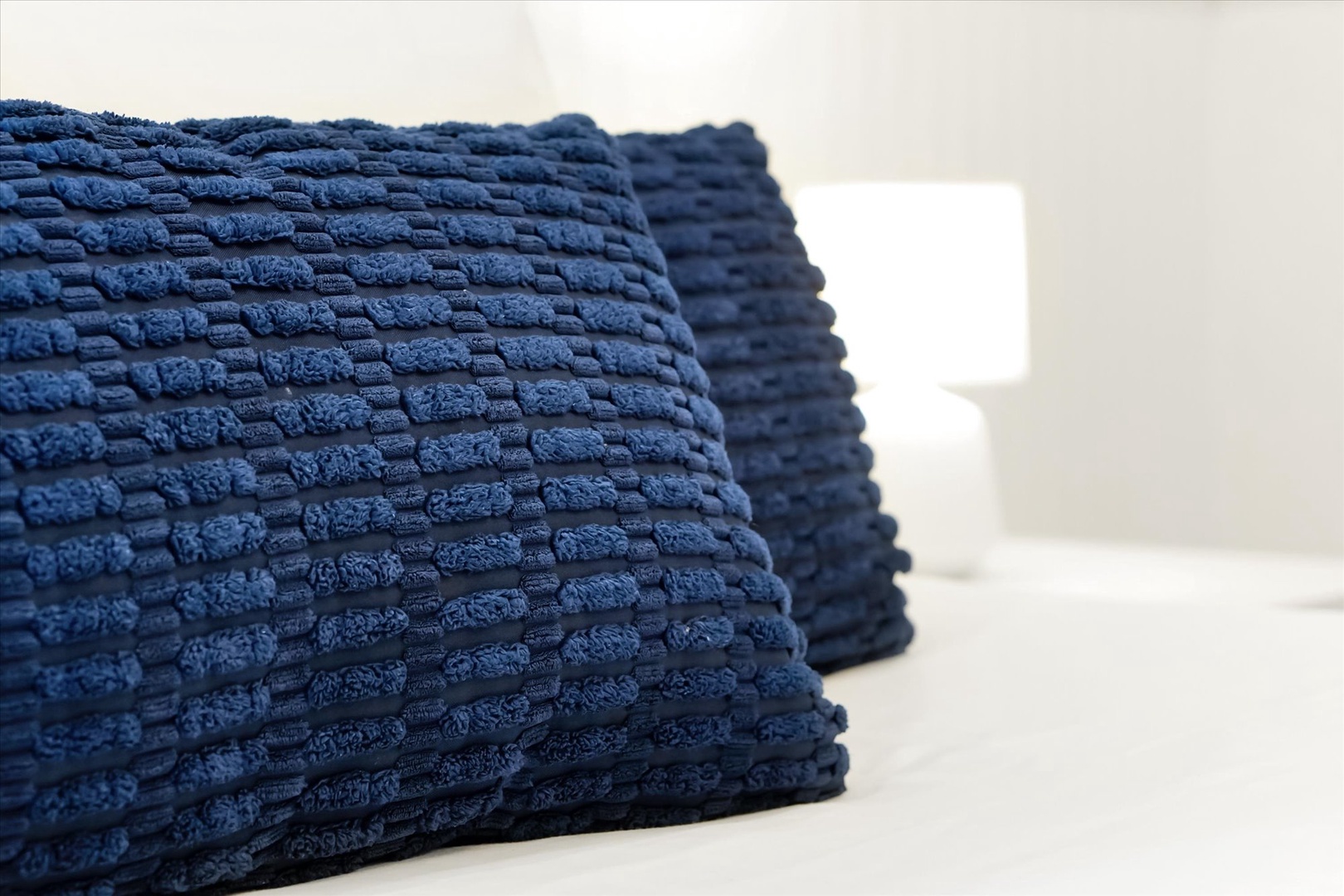 Rich navy textured pillows add a stylish, cozy touch to your relaxation space, inviting you to sink in and unwind.