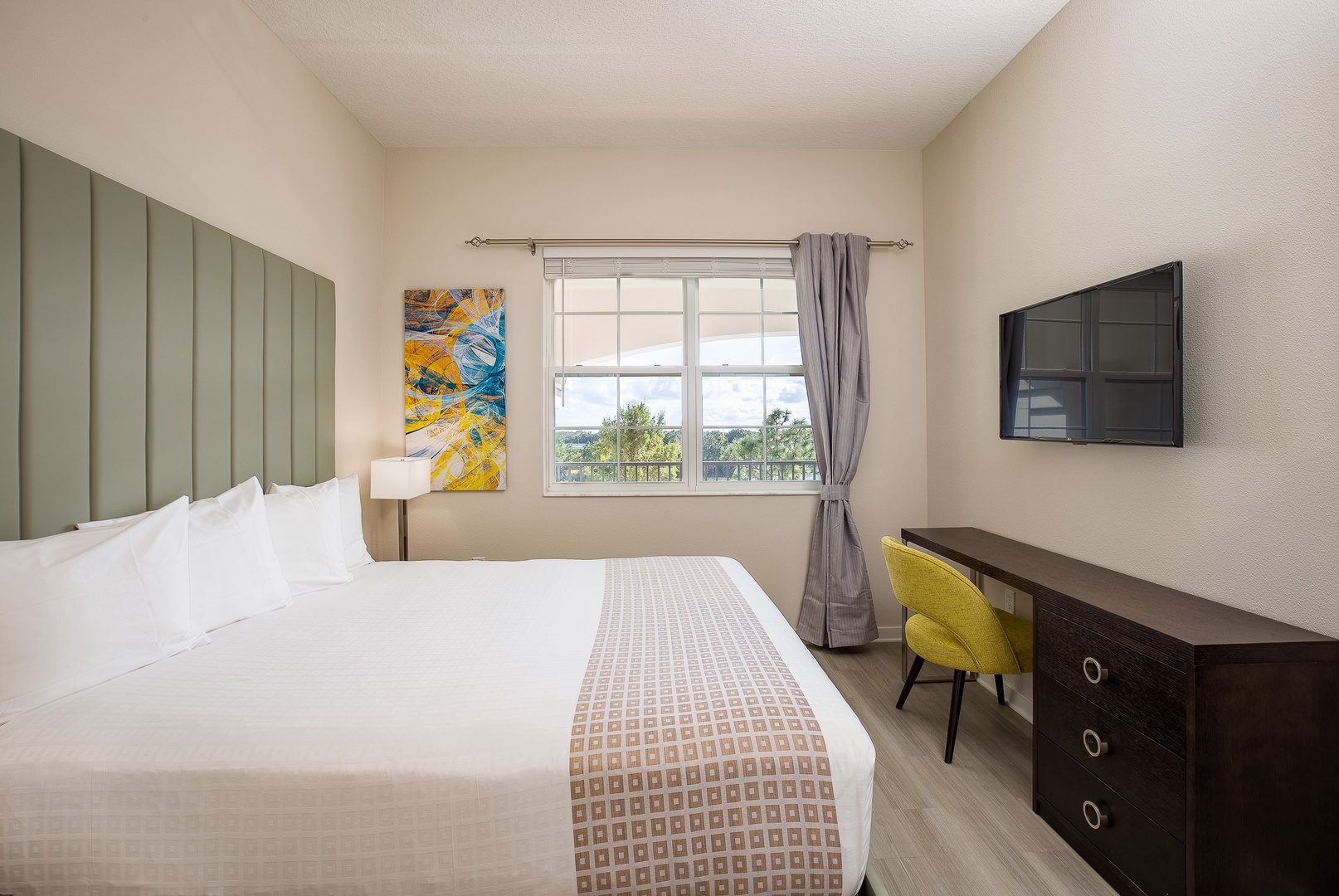 Your bright bedroom features a plush bed, modern workspace, and peaceful garden views from your private window.