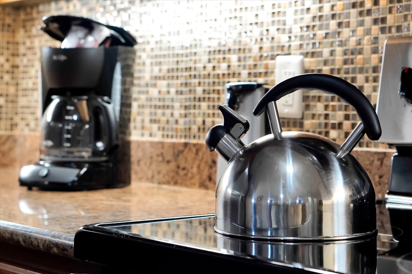 Your morning coffee ritual begins with this sleek kettle and coffee maker, perfectly positioned for easy brewing in your stylish kitchen.