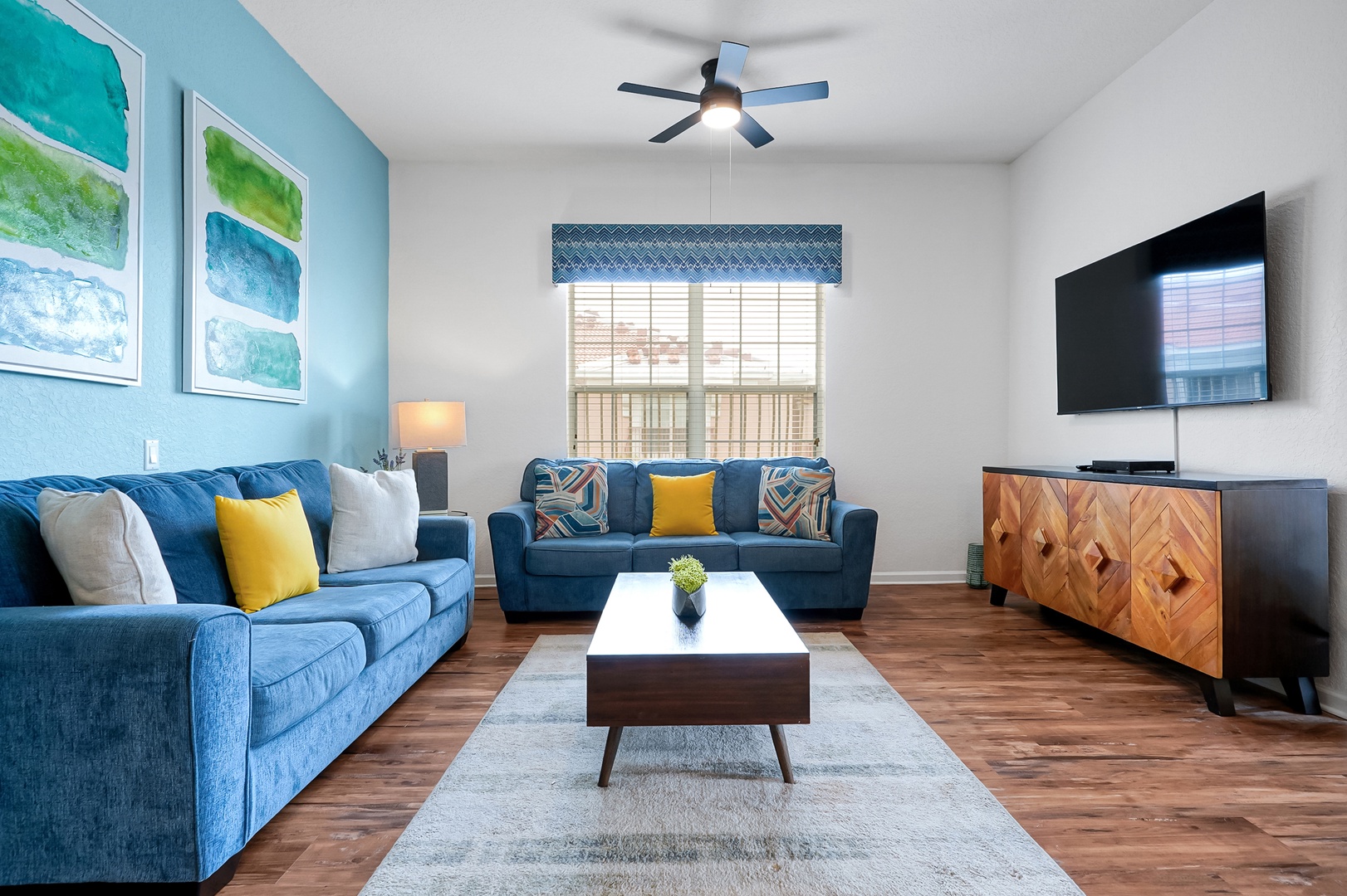 Your bright, coastal-inspired living room awaits with plush seating, ocean-hued accents, and warm wood floors that invite barefoot relaxation after a day of adventure.