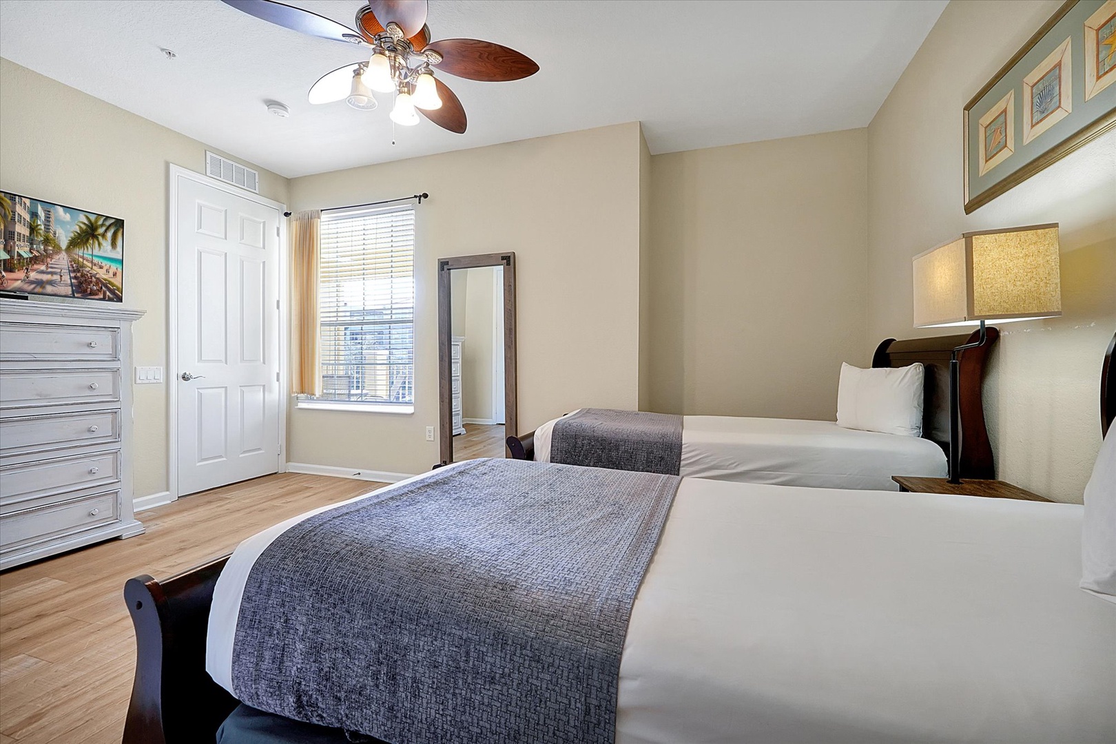 Unwind in your bright, comfortable twin bedroom with ceiling fan, dresser storage, and peaceful city views from your window.