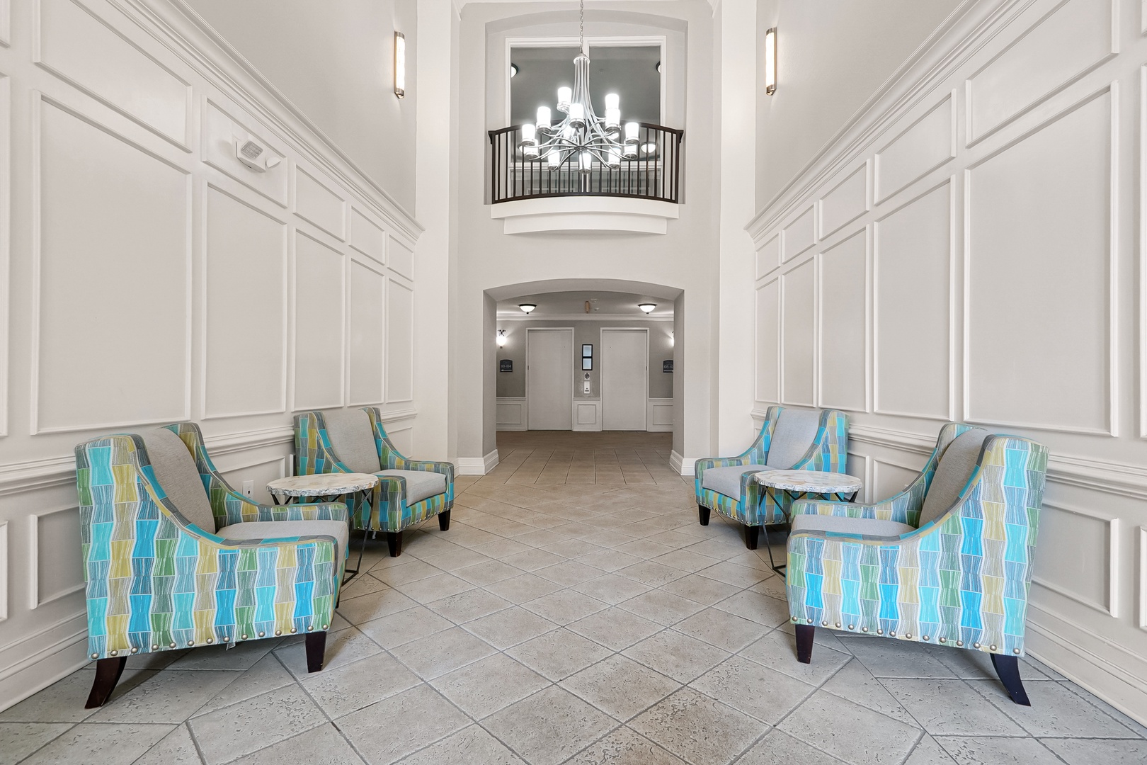 Elegant lobby with colorful striped seating and a chandelier above—your coastal getaway begins here.