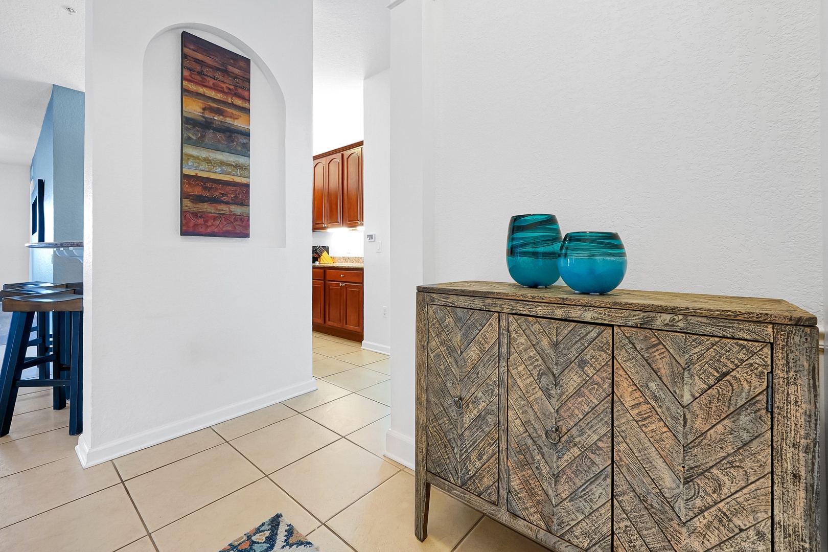 Bright archways and natural light invite you into this thoughtfully designed space, where colorful art and coastal accents create a welcoming, airy atmosphere.
