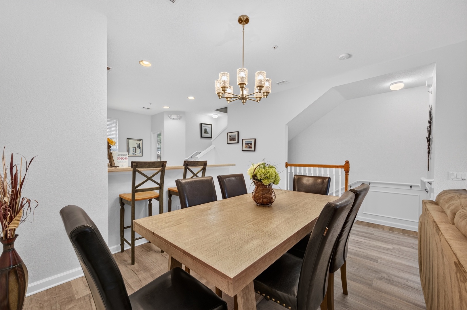 Your dining space awaits with a beautiful table for eight beneath a warm chandelier—perfect for shared meals and lasting memories with loved ones.