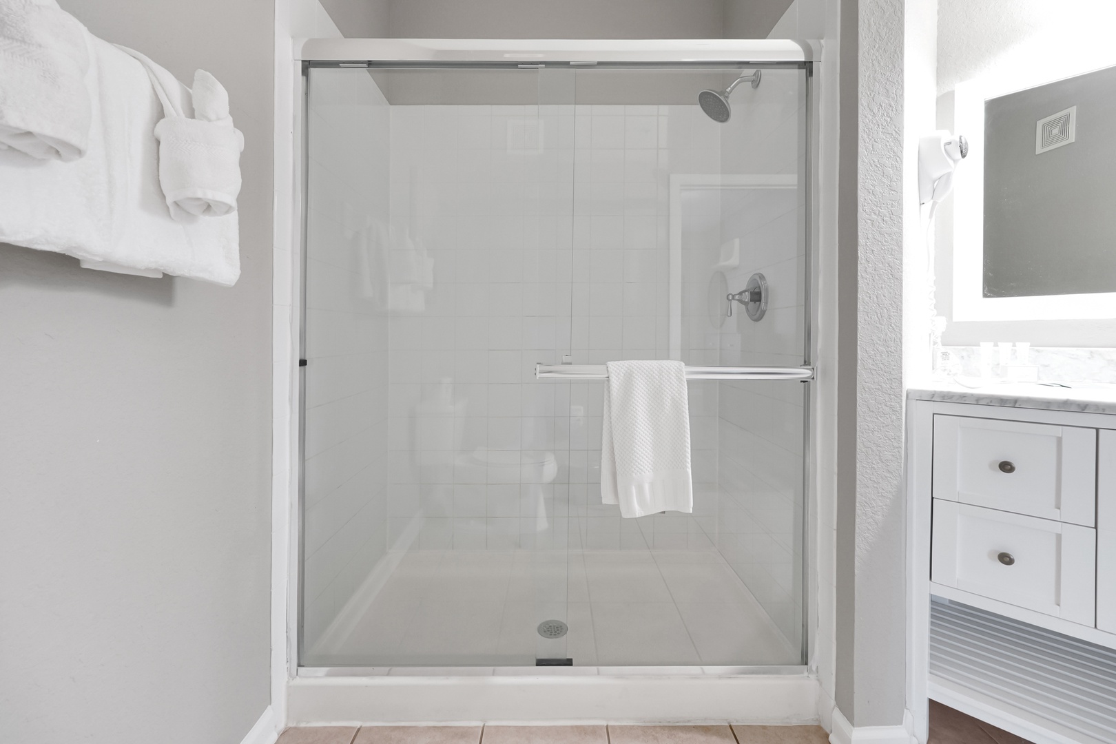 Step into your pristine walk-in shower with sleek glass doors and fresh towels ready for you—a clean, modern space where you'll start and end each day refreshed.
