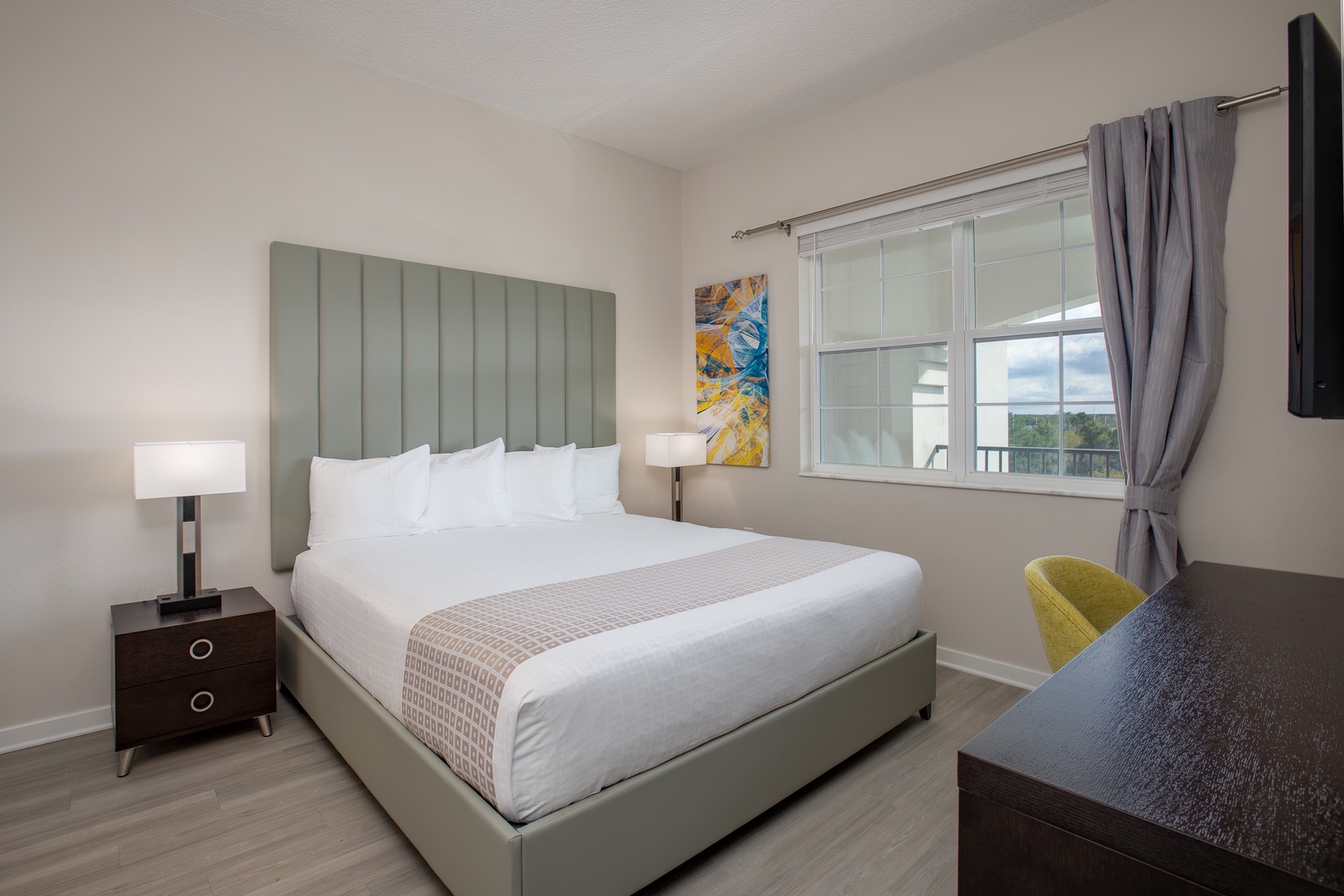 Your peaceful bedroom features a plush king bed with crisp linens, modern furnishings, and natural light streaming through your private window.