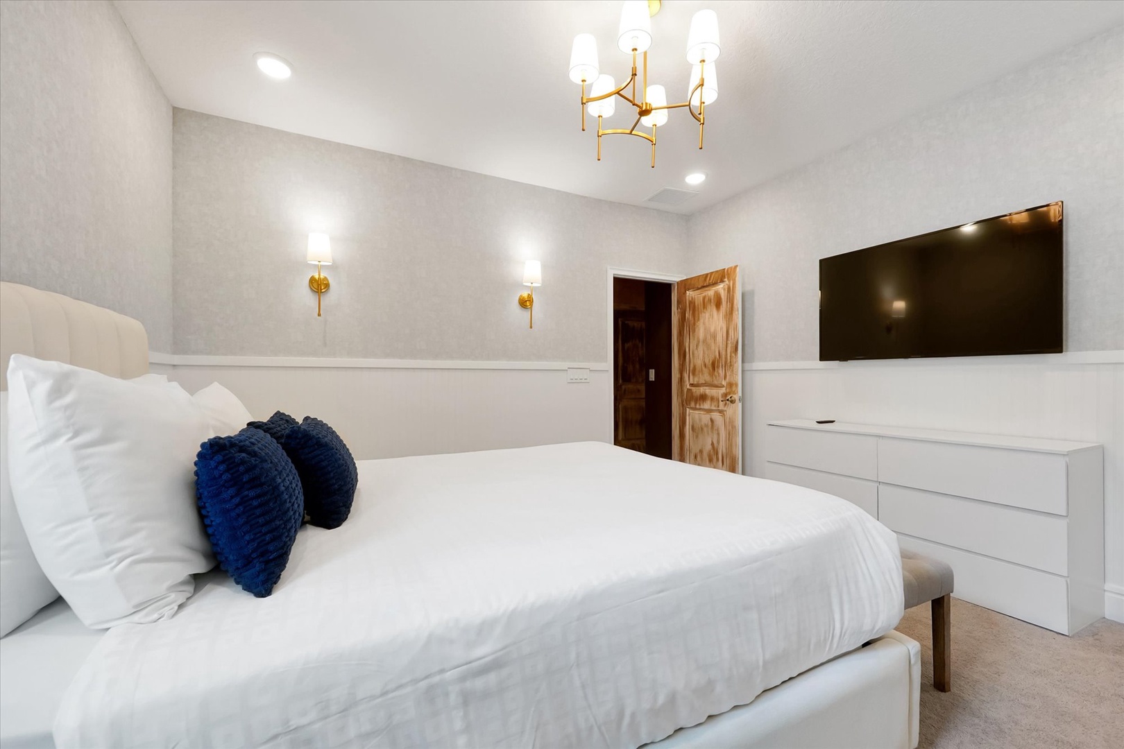 Sink into crisp linens and enjoy a restful night in your modern bedroom, complete with elegant lighting and a large flat-screen TV for your entertainment.