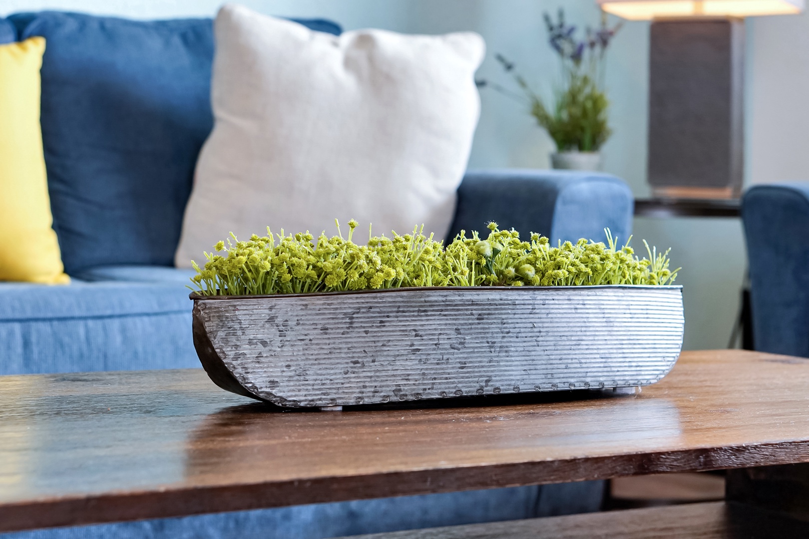 Settle into your inviting living space, where soft throws and cheerful accent pillows welcome you to unwind. A rustic wooden centerpiece brings a touch of nature to your relaxing retreat.