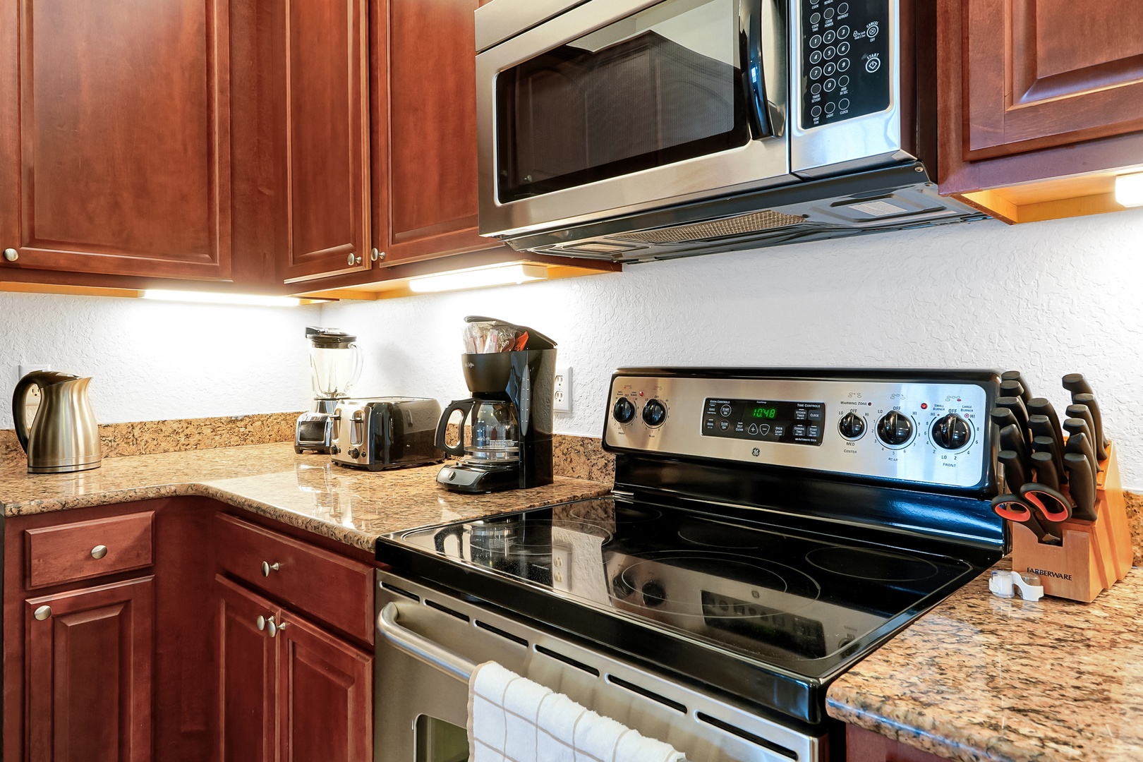 Your fully equipped kitchen features modern appliances and granite counters, perfect for preparing meals during your stay. Everything you need—from coffee maker to stove—awaits.