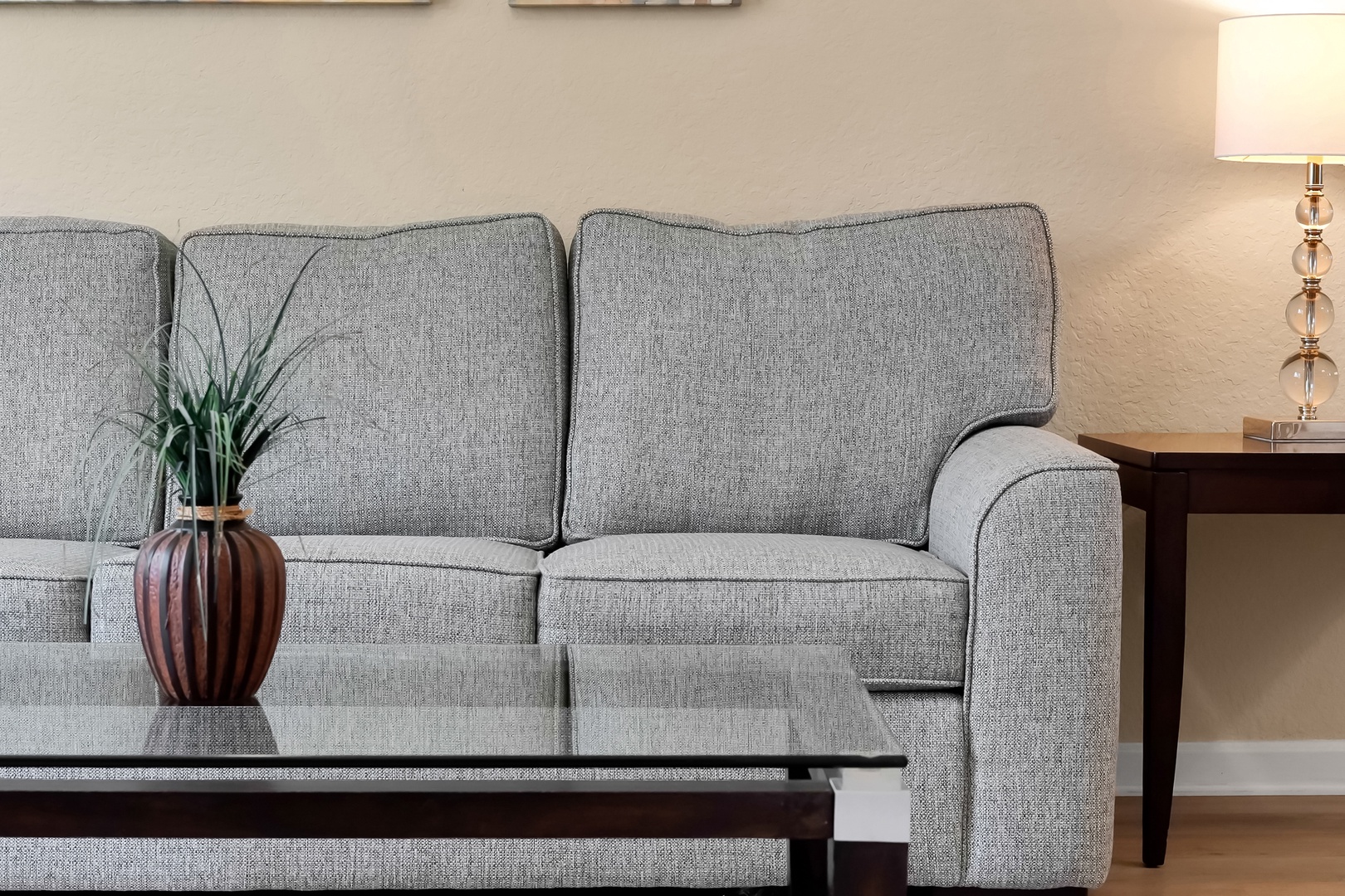 Sink into comfort on your plush gray sofa, perfectly positioned for relaxing evenings with soft lamp lighting creating the ideal ambiance.
