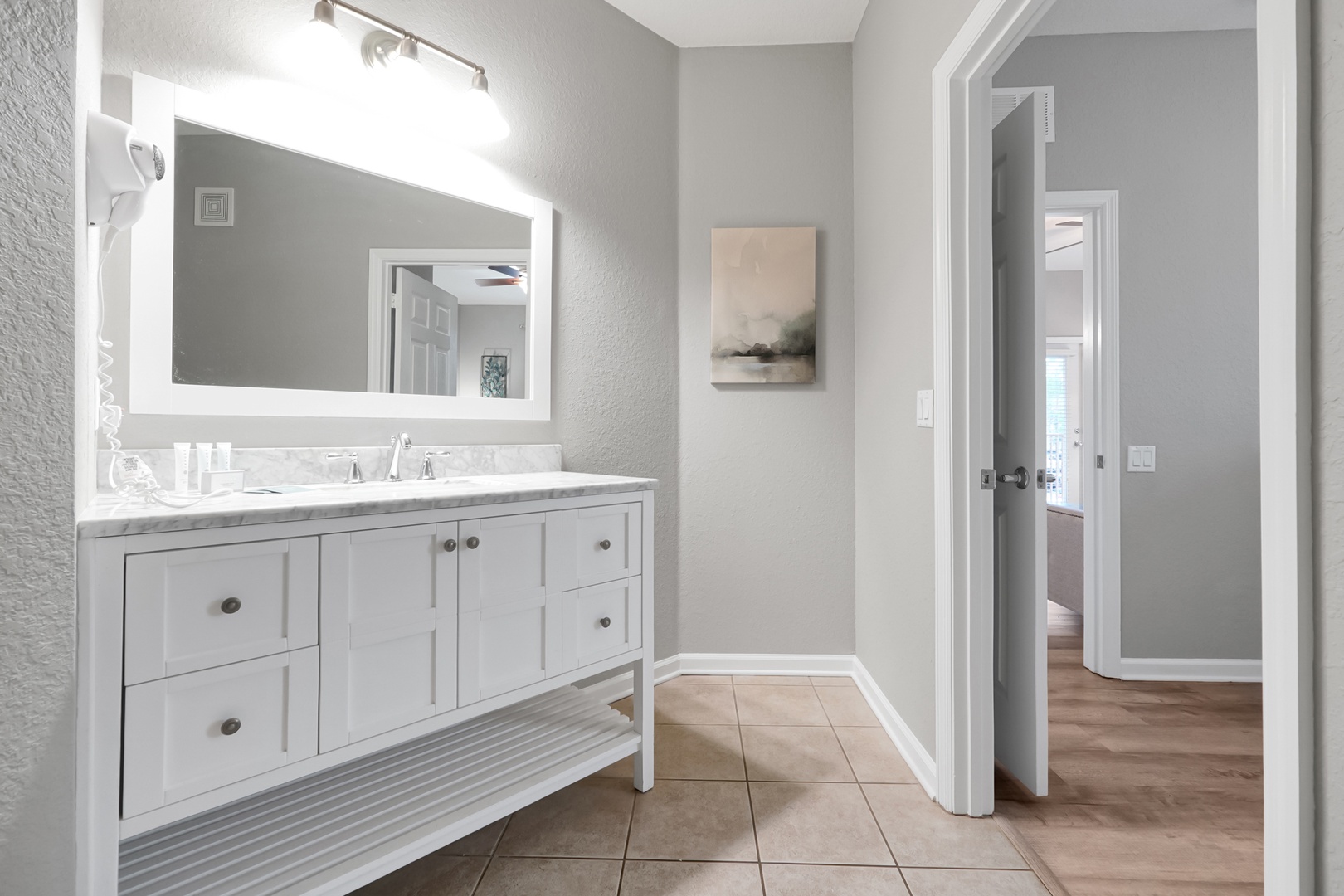 Freshen up in your stylish ensuite with a marble-topped vanity, crisp white cabinetry, and bright lighting that makes mornings feel effortless.